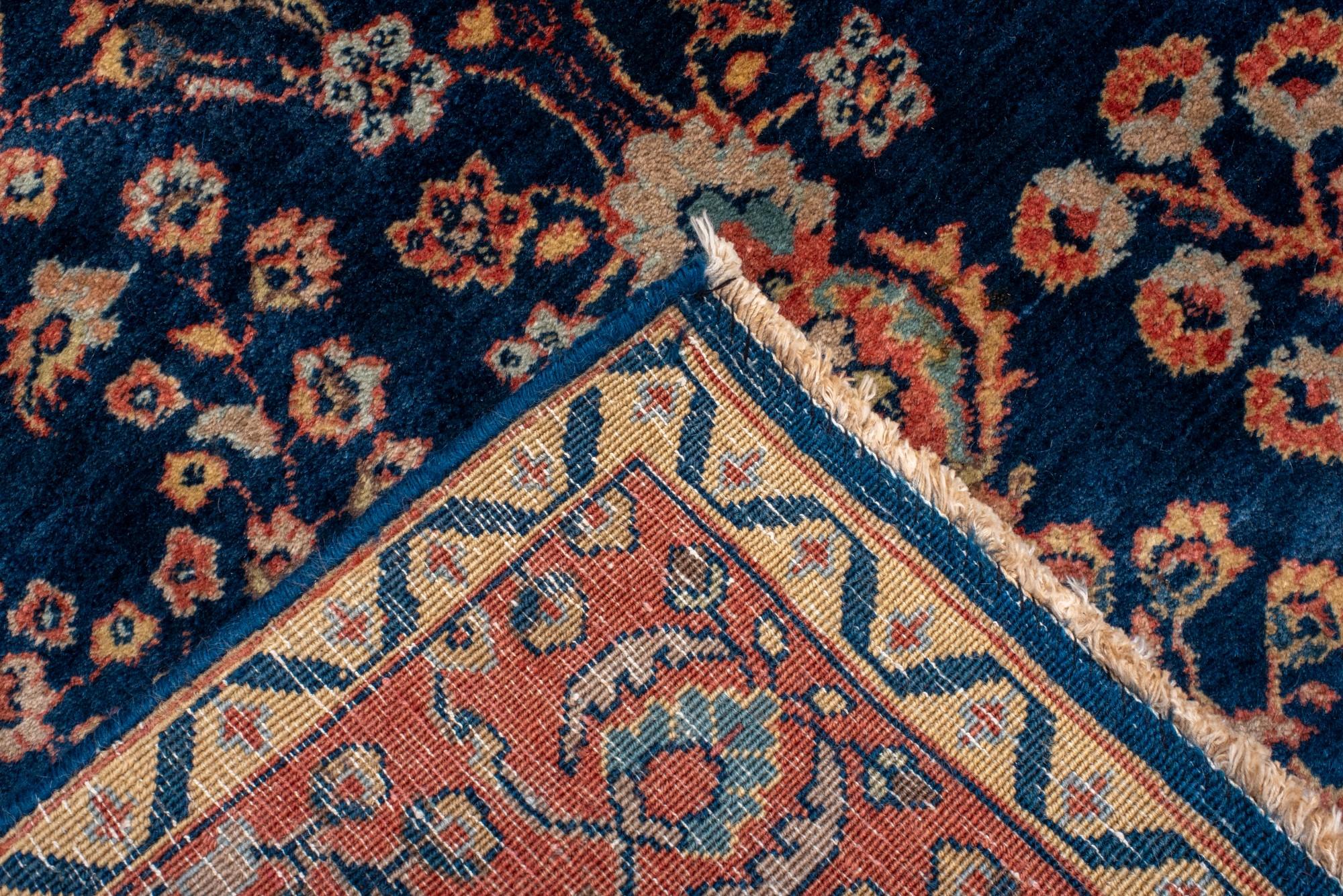 Sarouk antiguo con fondo azul marino y borde rojo siglo XX en venta