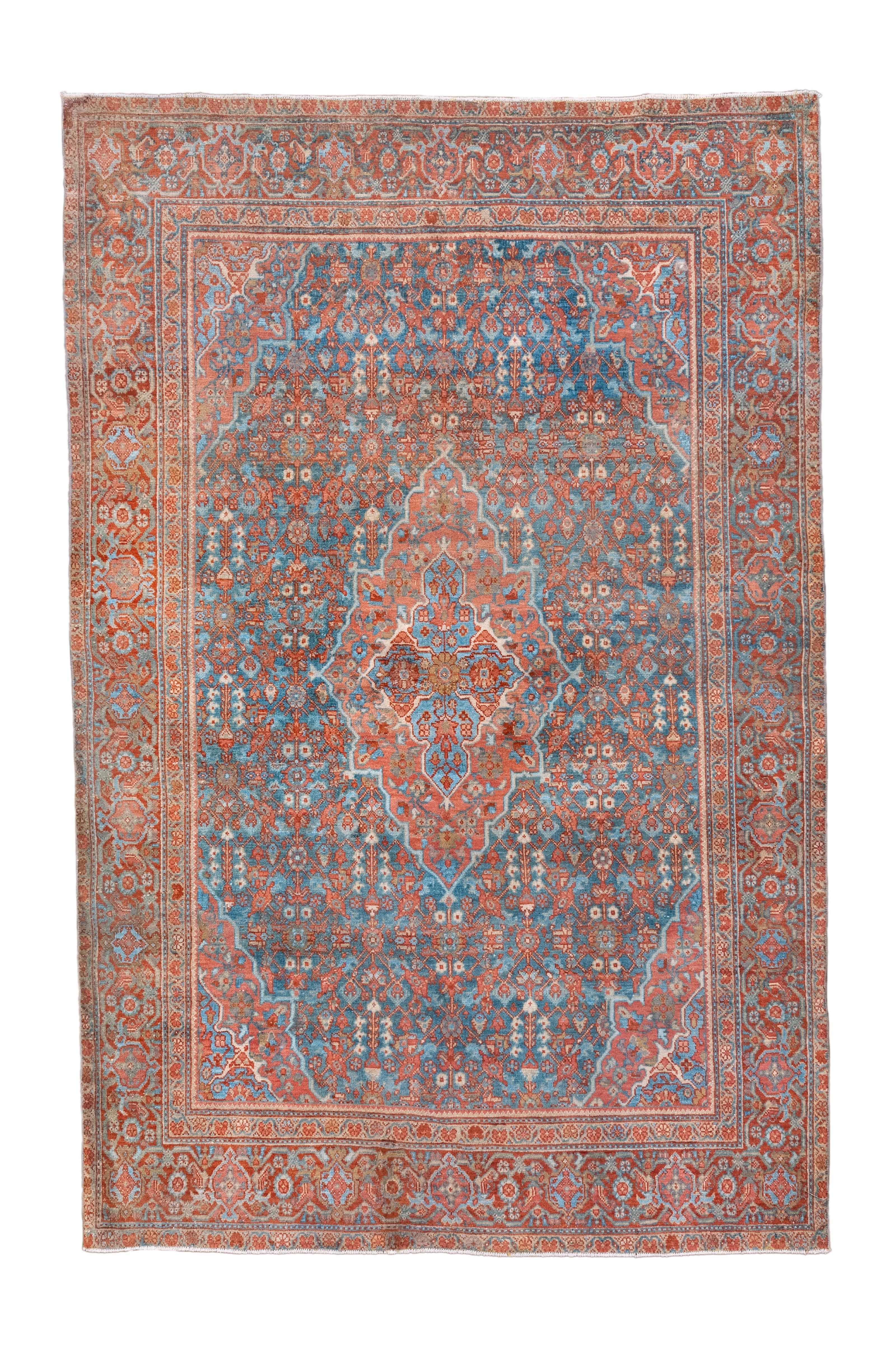Le champ bleu moyen supporte un motif idiosyncrasique répétitif allover, à sens unique, lié au Gol Hennai, avec des tiges droites faisant jaillir de petites fleurs écrues, des palmettes à pétales, des feuilles barbelées et d'autres dispositifs