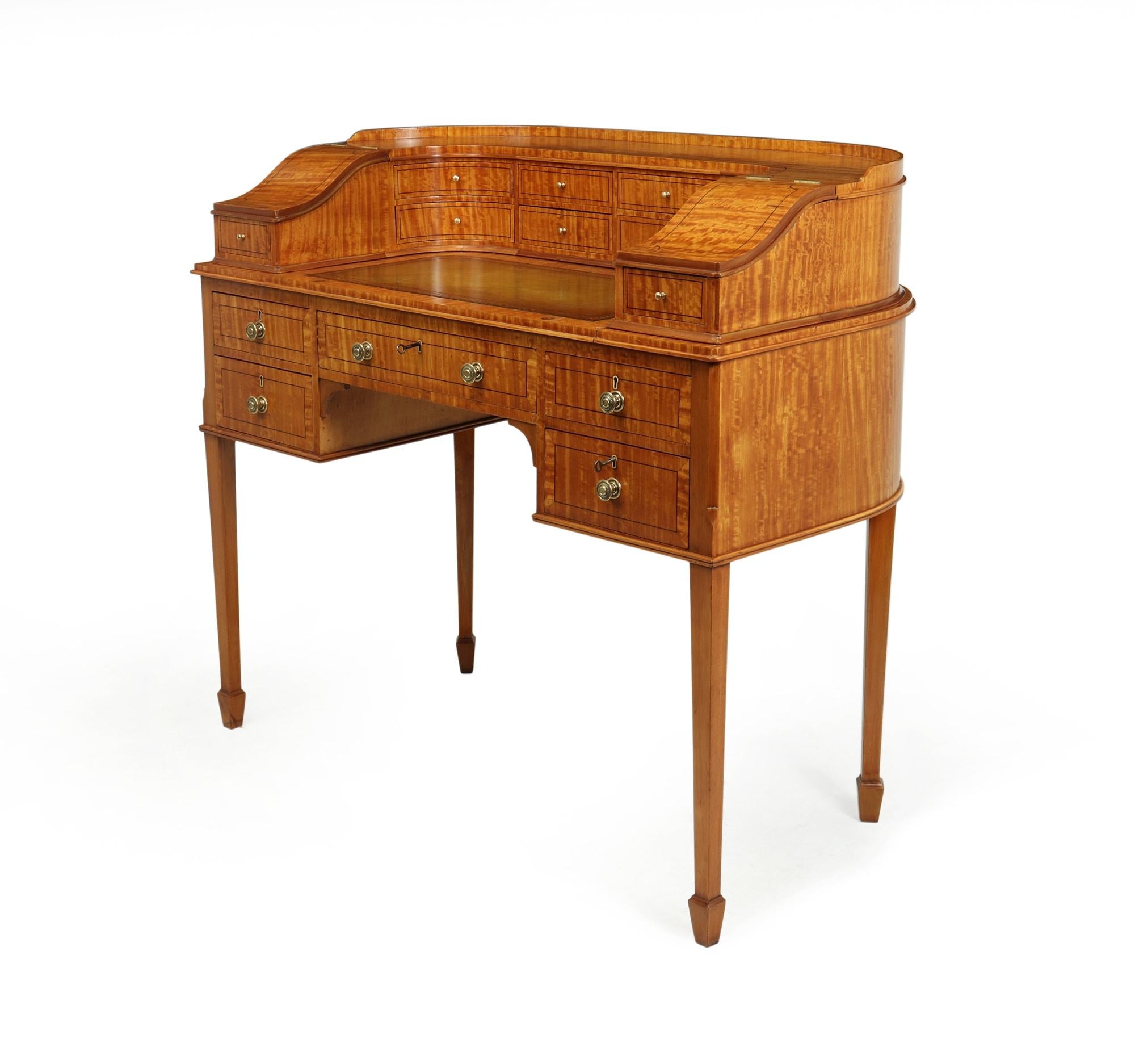 This is a beautiful antique, mahogany and satinwood with ebony string lining Carlton House desk. There are plenty of storage compartments to accommodate all of your stationery. In addition to the ten smaller drawers, there are five larger lockable