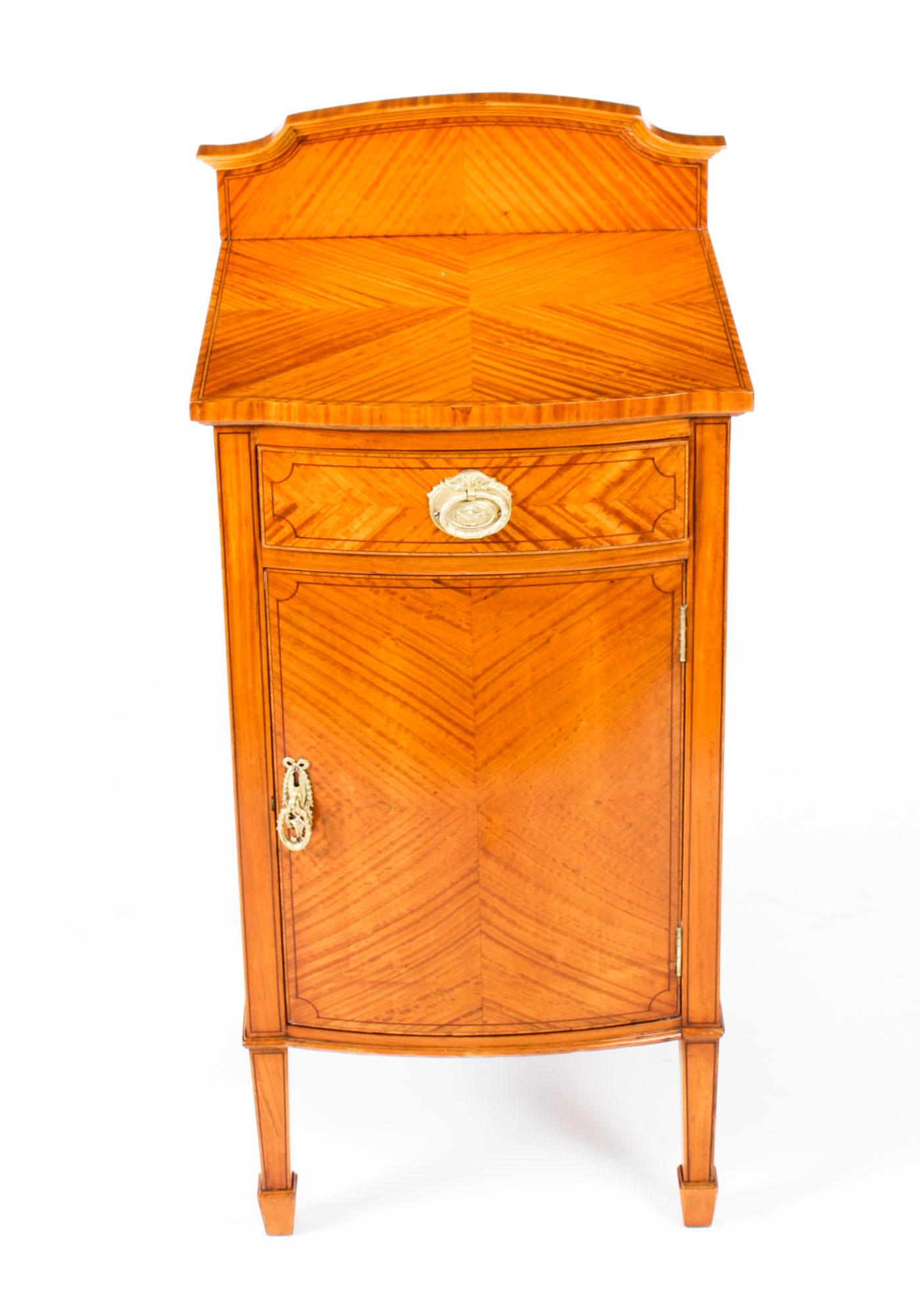 This is a splendid antique Victorian satinwood bedside cabinet, circa 1880 in date.

The cabinet features quarter veneered satinwood with decorative ebonized line inlay. It has a frieze drawer above a cupboard with a central shelf and is raised on