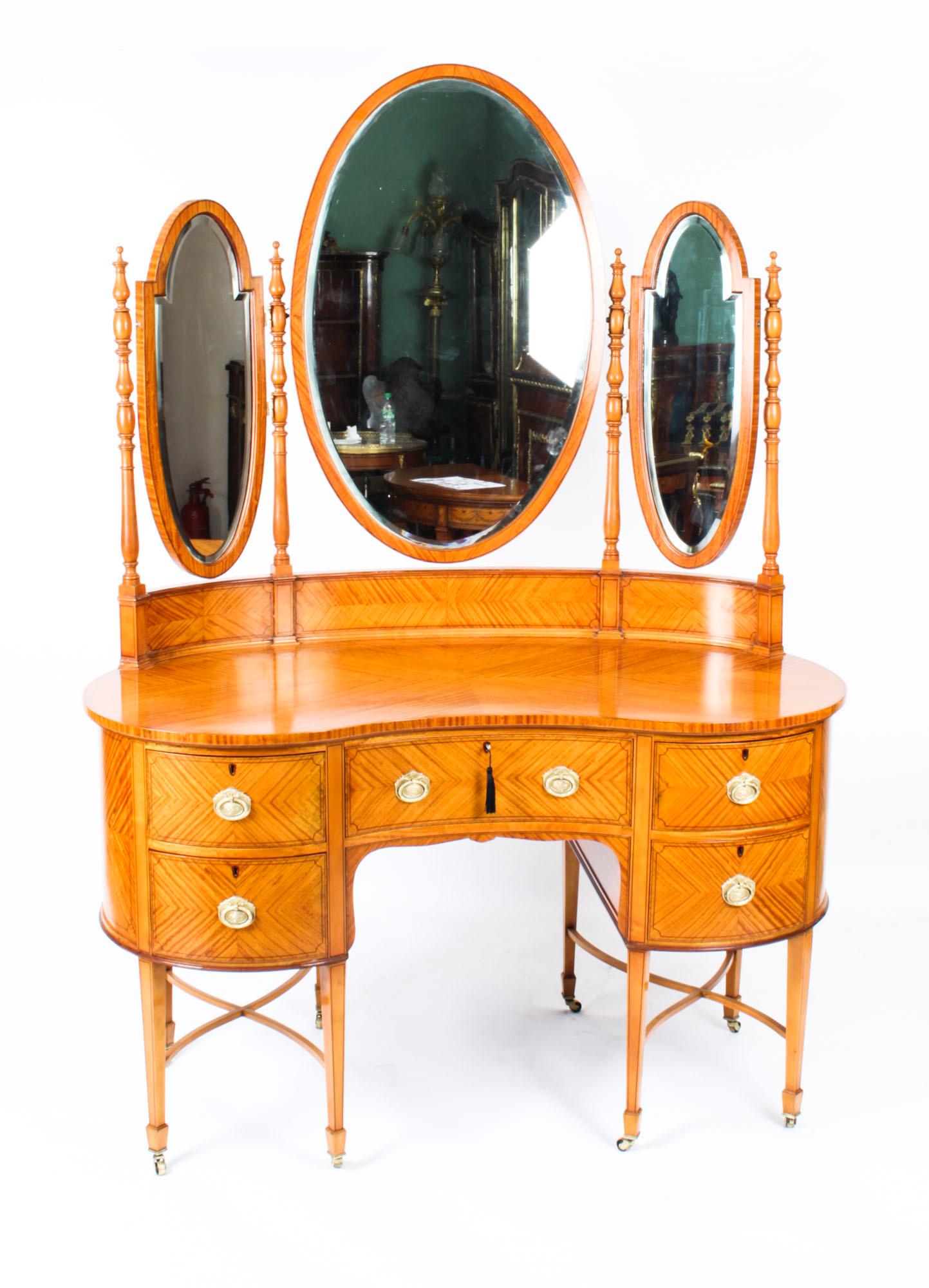 This is a totally fabulous antique satinwood kidney shaped dressing table with ebonised inlay, attributed to Maple & Co, circa 1880 in date.

The stunning satinwood with ebonized line inlay and crossbanding. It has a useful central drawer, a pair