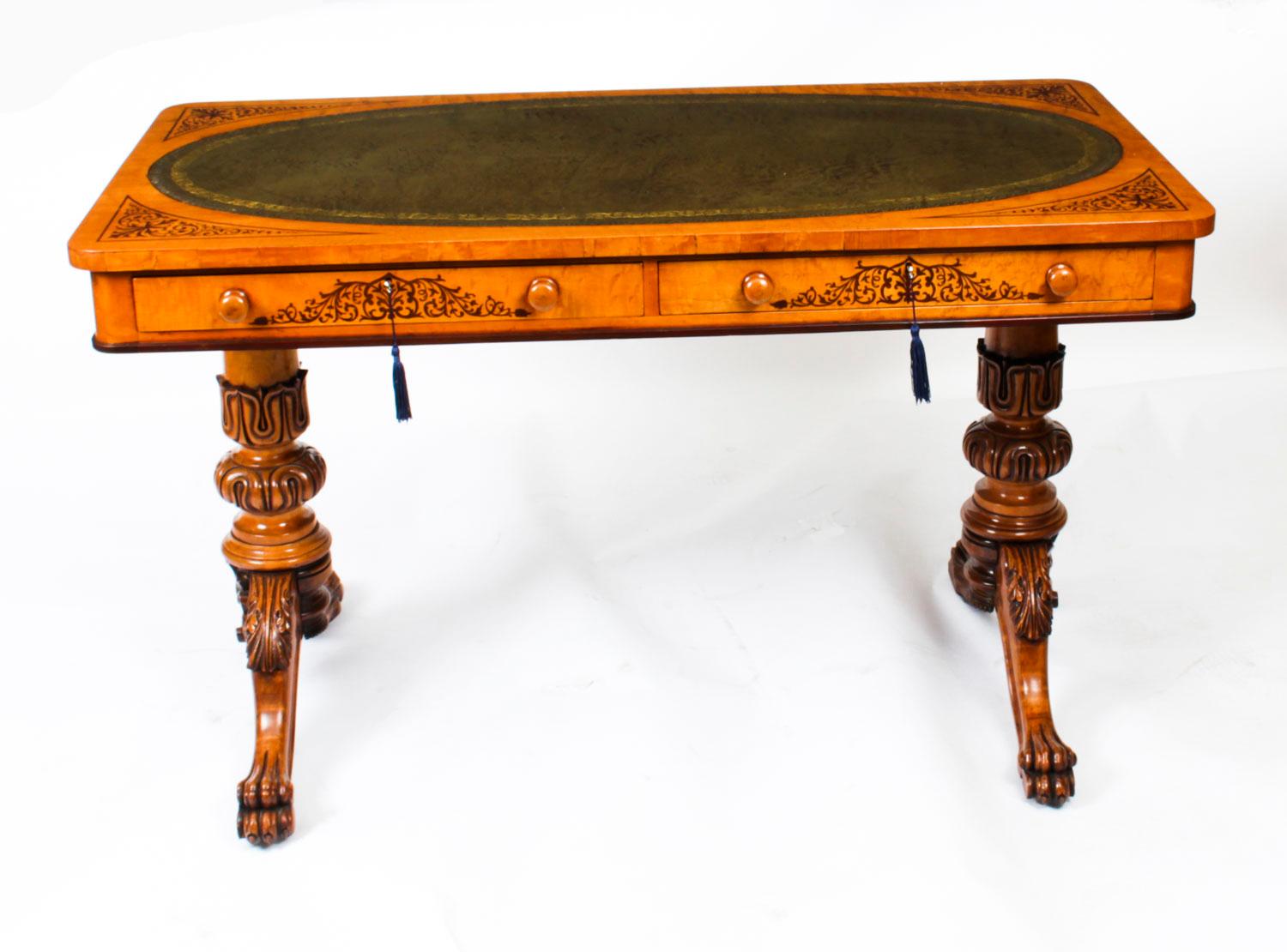 This is a fine antique early Victorian satinwood Marquetry writing table in the manner of Gillows and circa 1840 in date.
 
The rectangular shaped top features a central inset oval tooled olive green leather writing surface with decorative