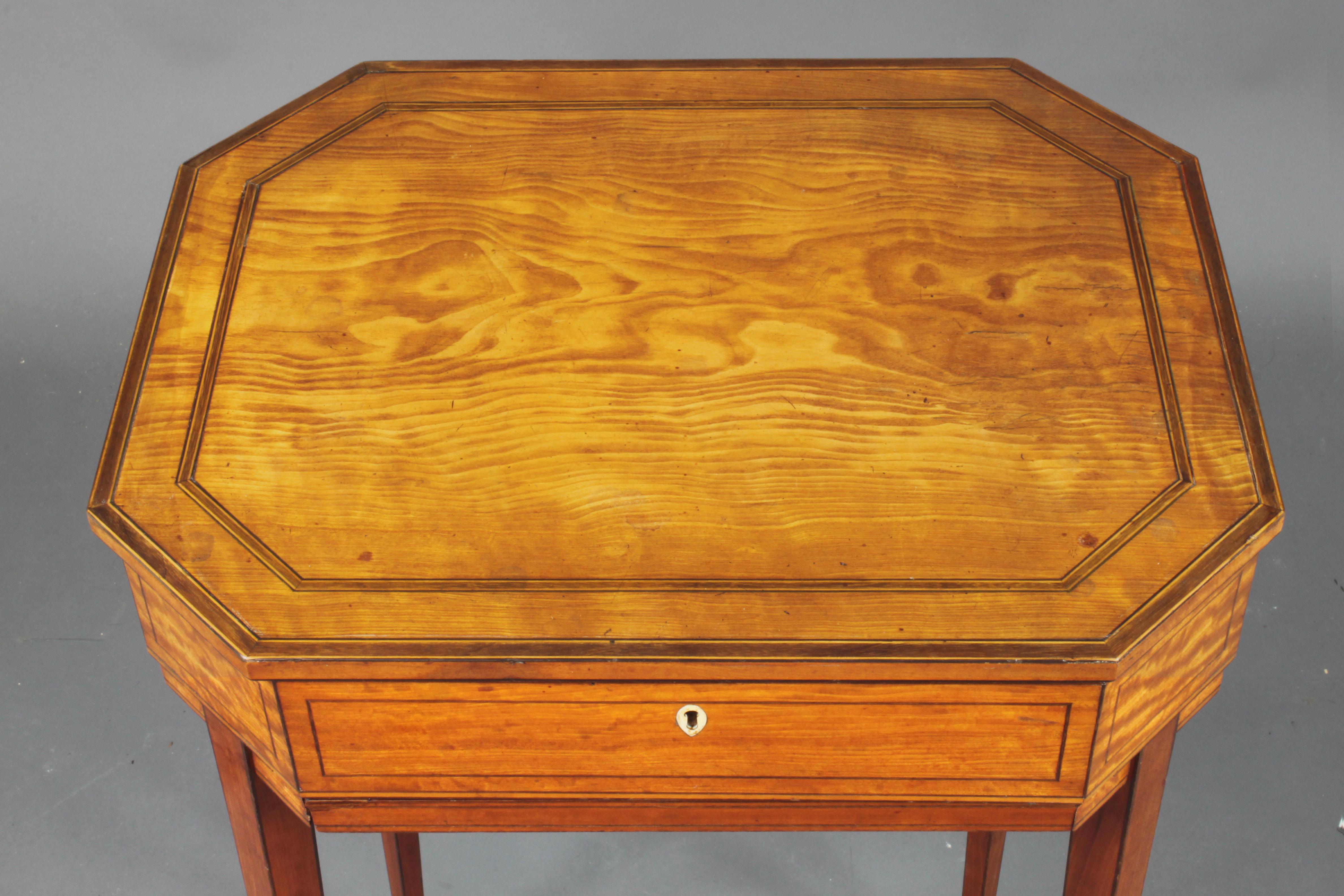 A very elegant small satinwood work table with a crossbanded top and slender tapered legs. The original top frame of the bag underneath has been made into a slide.