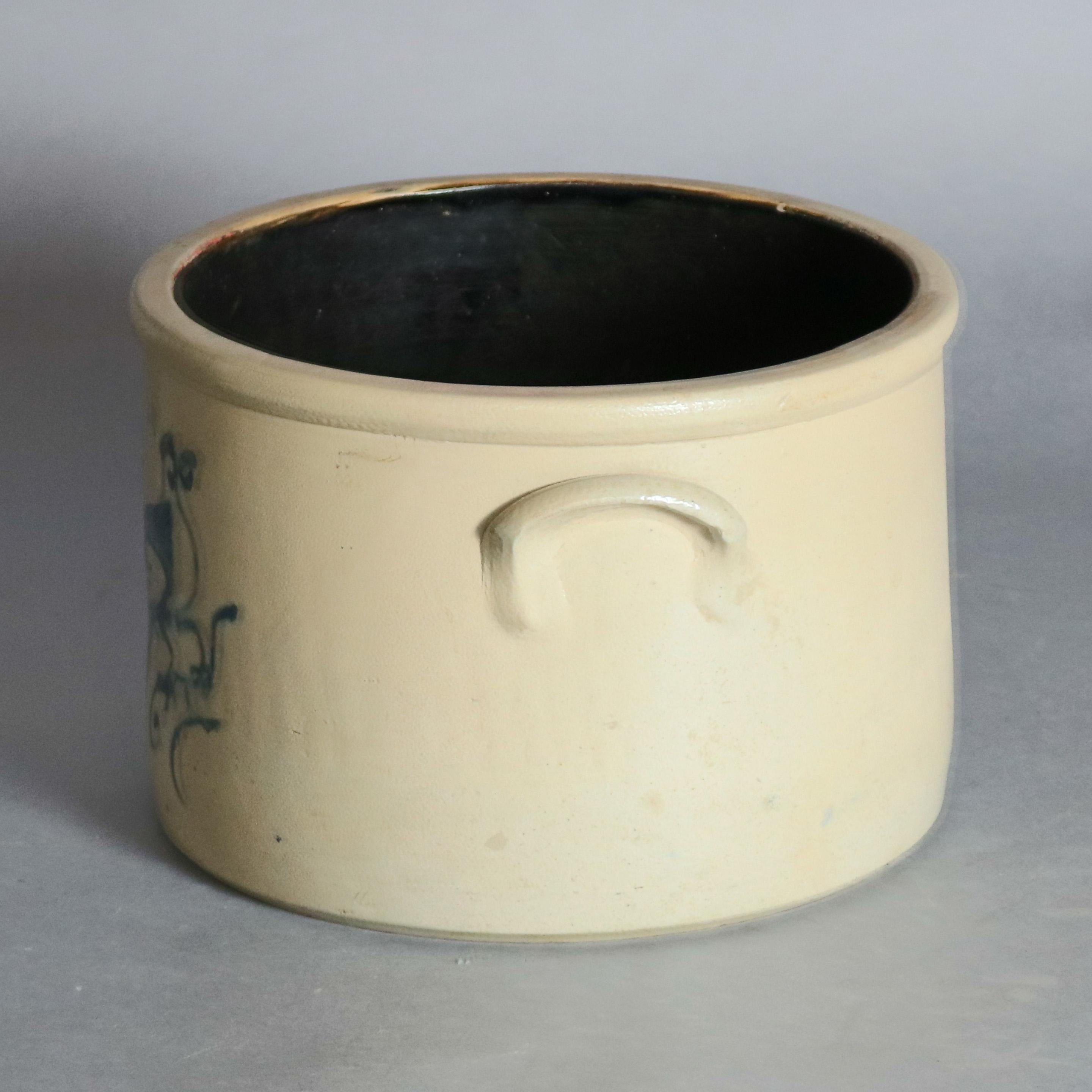 An antique stoneware cake crock by Satterlee and Mory, Fort Edward, NY offers cylindrical form with lug handles and hand decorated in cobalt blue with a bird and branch design, impressed maker stamp above 