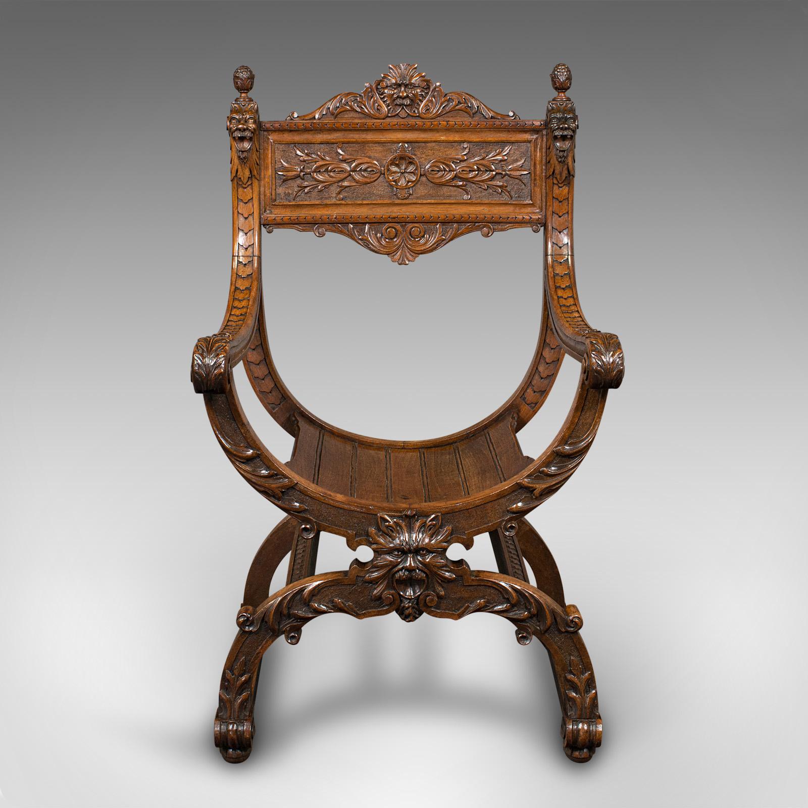 This is an antique Savonarola armchair. An English, walnut seat with overt Gothic revival overtones by James Shoolbred, dating to the Victorian period, circa 1880.

So named for the 15th century Italian Dominican priest Girolamo Savonarola, the