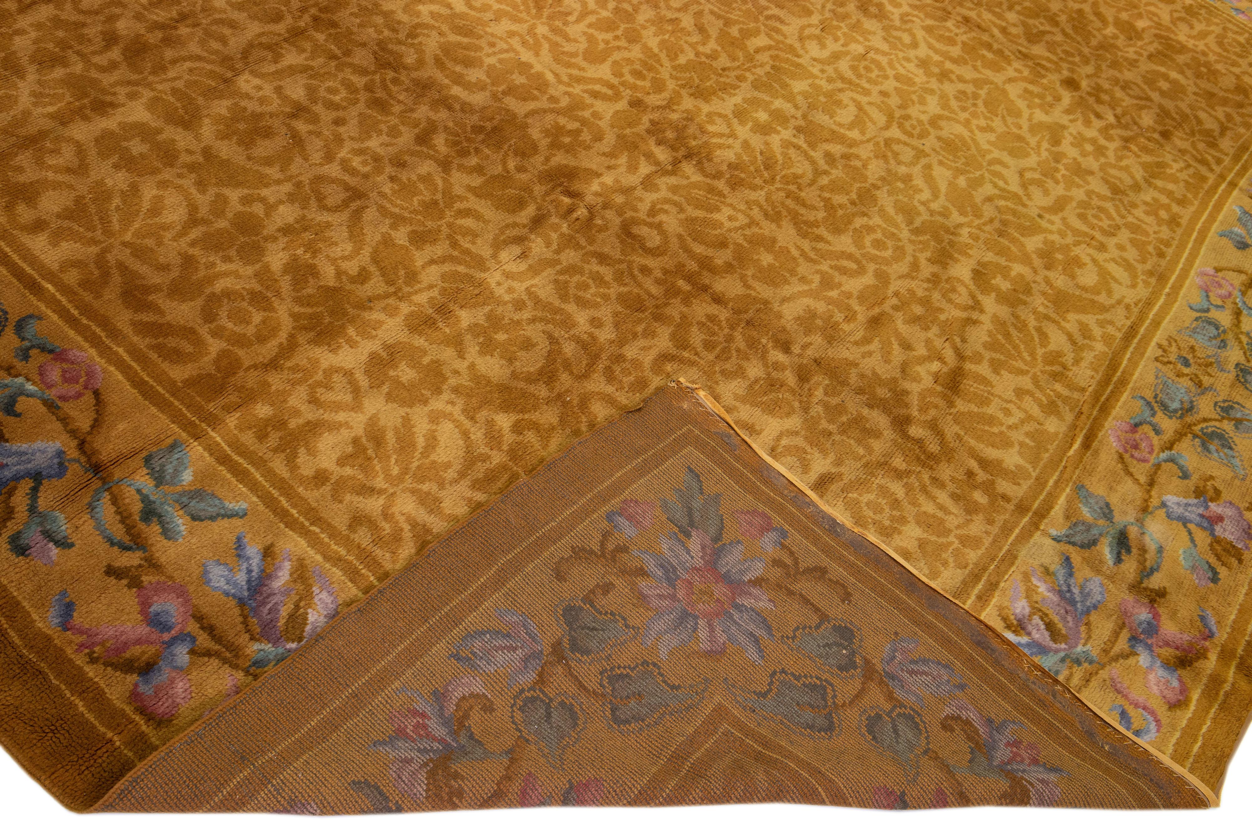 Beautiful antique Savonnerie hand-knotted wool rug with a goldenrod field. This piece has a designed frame and brown accents in a gorgeous all-over floral pattern design.

This rug measures: 12' x 17'6''.