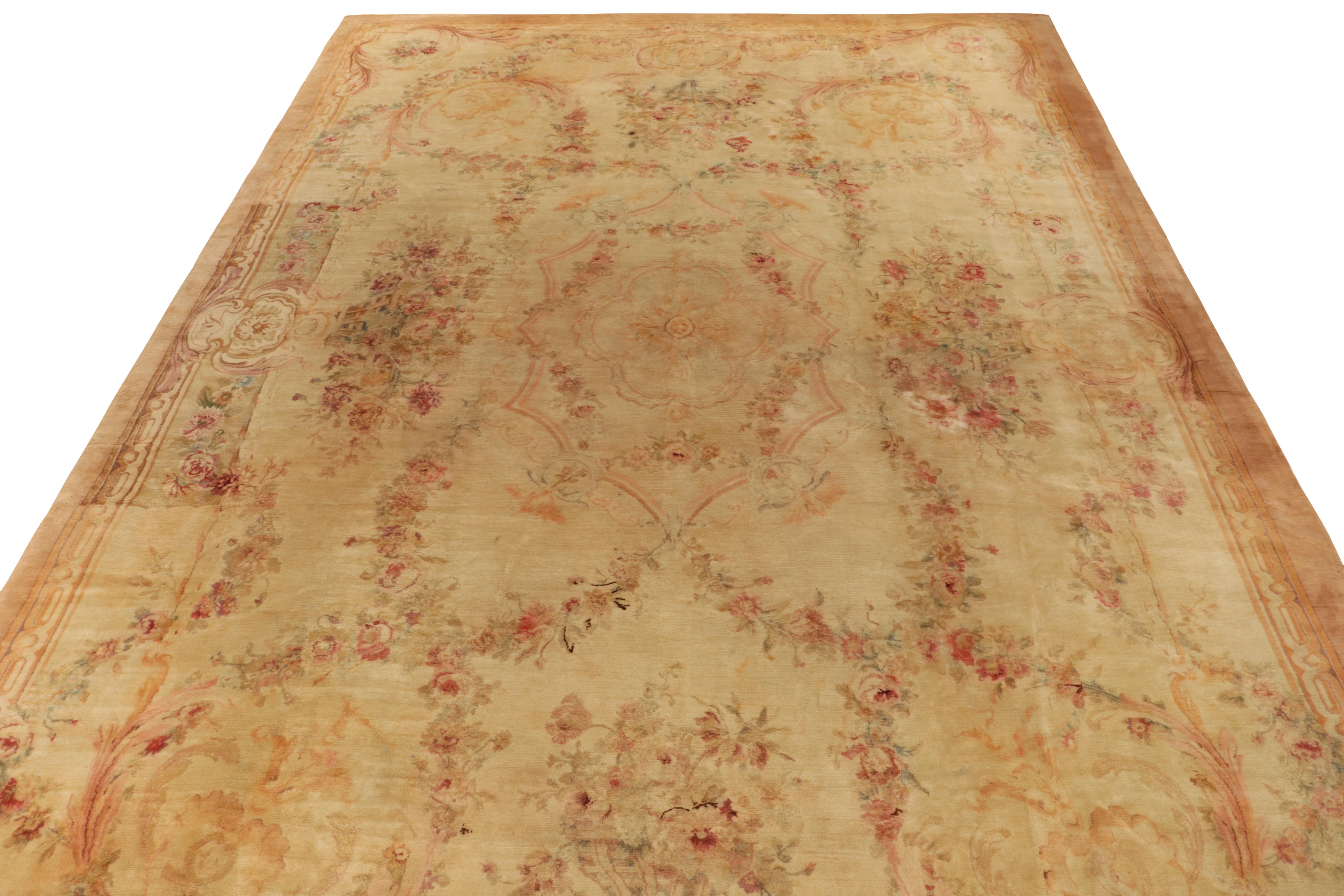 Hand-knotted in lush wool pile, this 14x22 antique Savonnerie rug exemplifies the impeccable French craftsmanship of the late 19th century. This classic style enjoys an expansive floral pattern in comforting beige & gold tones accenting to soft pink