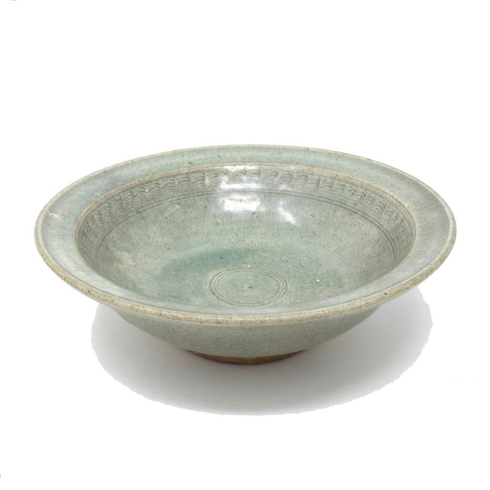 Antique Sawakhalok Celadon Bowl, Thailand 14th/15th century.
A sturdily potted wheel thrown stoneware bowl with everted rim and flattened lip. The deep cavetto has an upper decorative band of combed broken comma pattern enclosed above and below by
