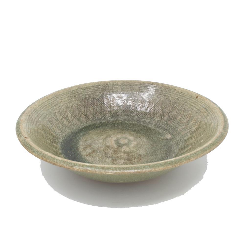 Antique Sawakhalok Celadon Bowl, Thailand 14th/15th century.
A sturdily potted wheel thrown stoneware bowl with everted rim and chamfered lip. The cavetto has a three line combed decorative lattice pattern enclosed above and below by several incised