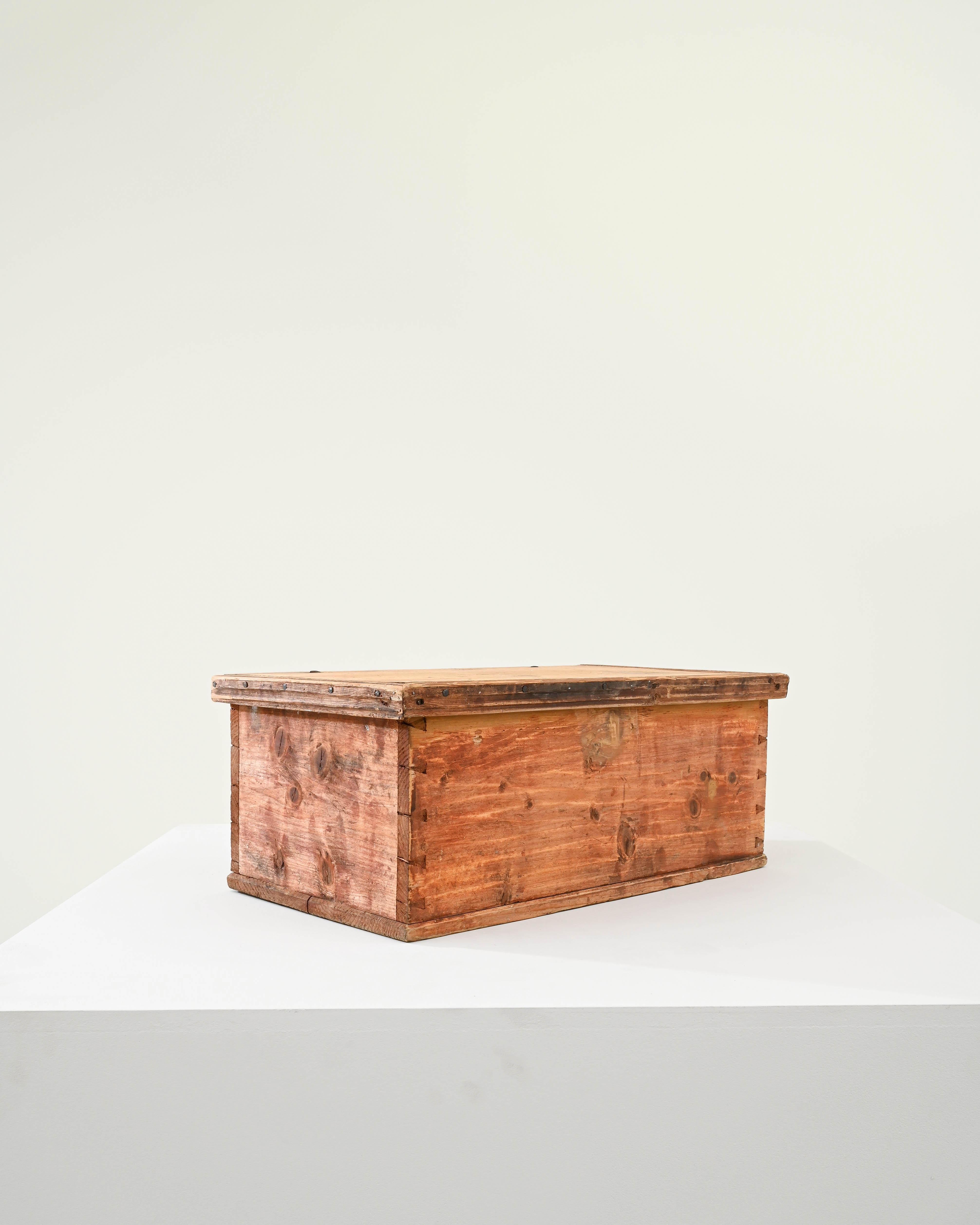 Cette boîte en bois a été produite en Scandinavie, vers 1900. Une boîte à claque patinée montrant les signes d'une existence usée par le temps, avec des ferrures métalliques d'origine. Habilement clouée et assemblée à l'aide de queues d'aronde