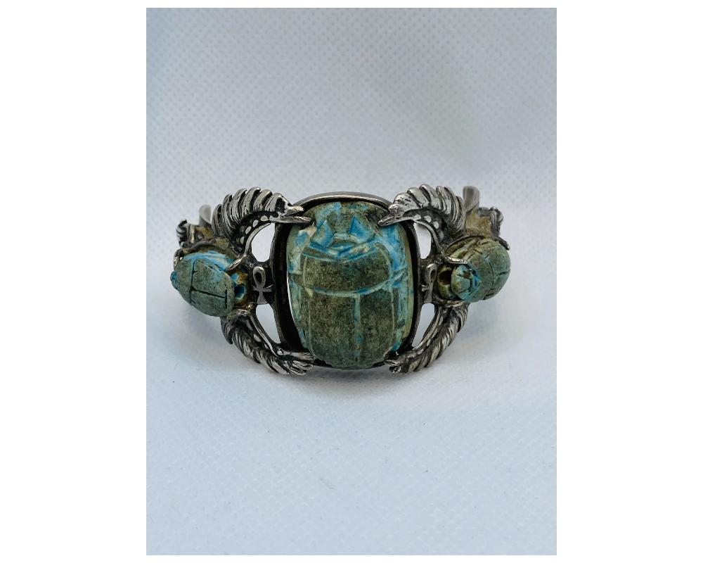 Bracelet en faïence égyptienne ancienne

En très bon état, voir les photos.

La taille est d'environ 2 ½ pouces de haut en bas, voir les photos. 
La largeur de la partie centrale est d'environ 1 ½ pouce.