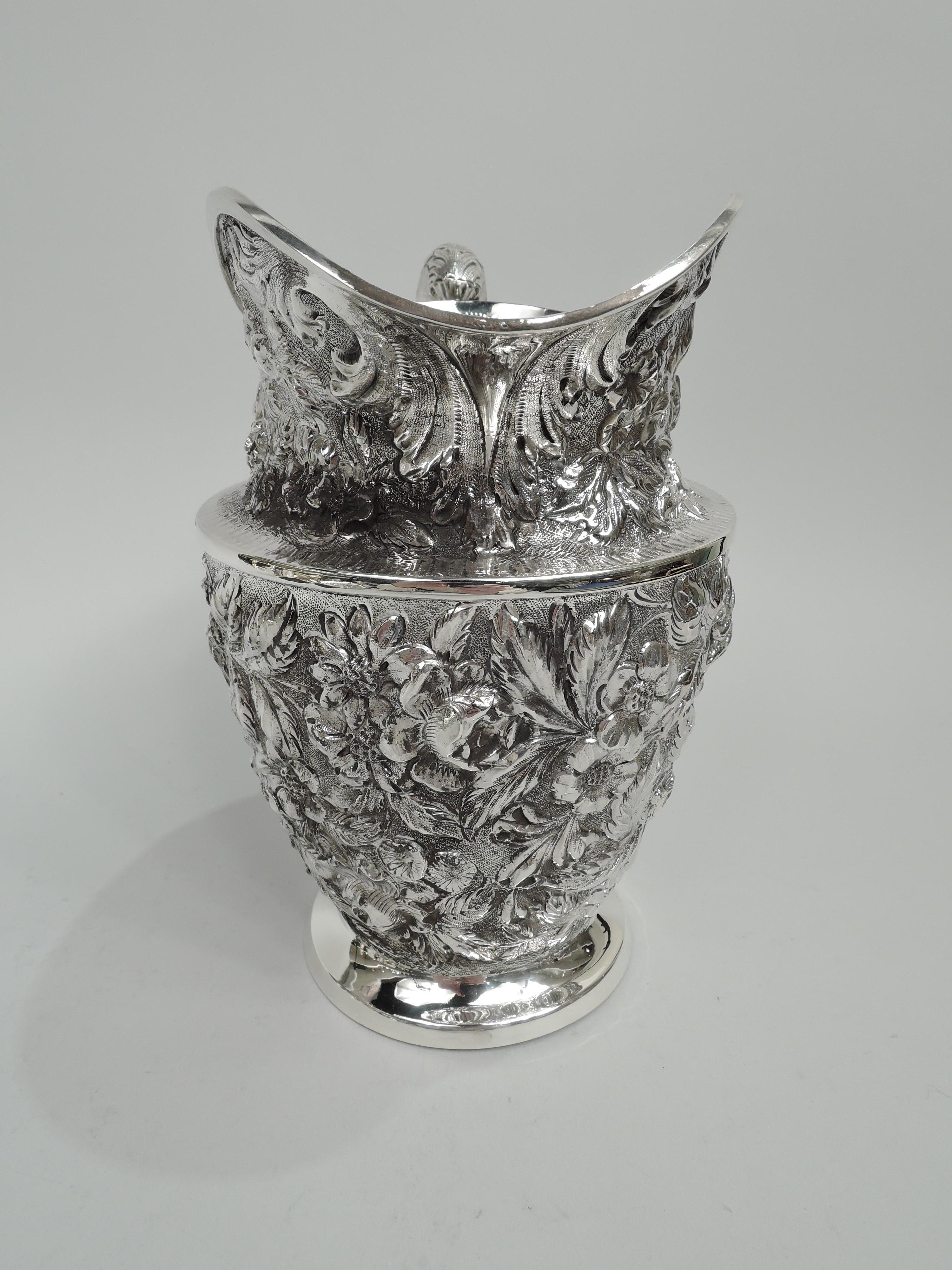 Baltimore Rose sterling silver water pitcher. Made by Schofield in Baltimore, circa 1910. Tapering sides, flat shoulder with tooled lines, helmet mouth, and leaf-capped high-loping handle; foot plain and raised. Repousse in form of big blooms and