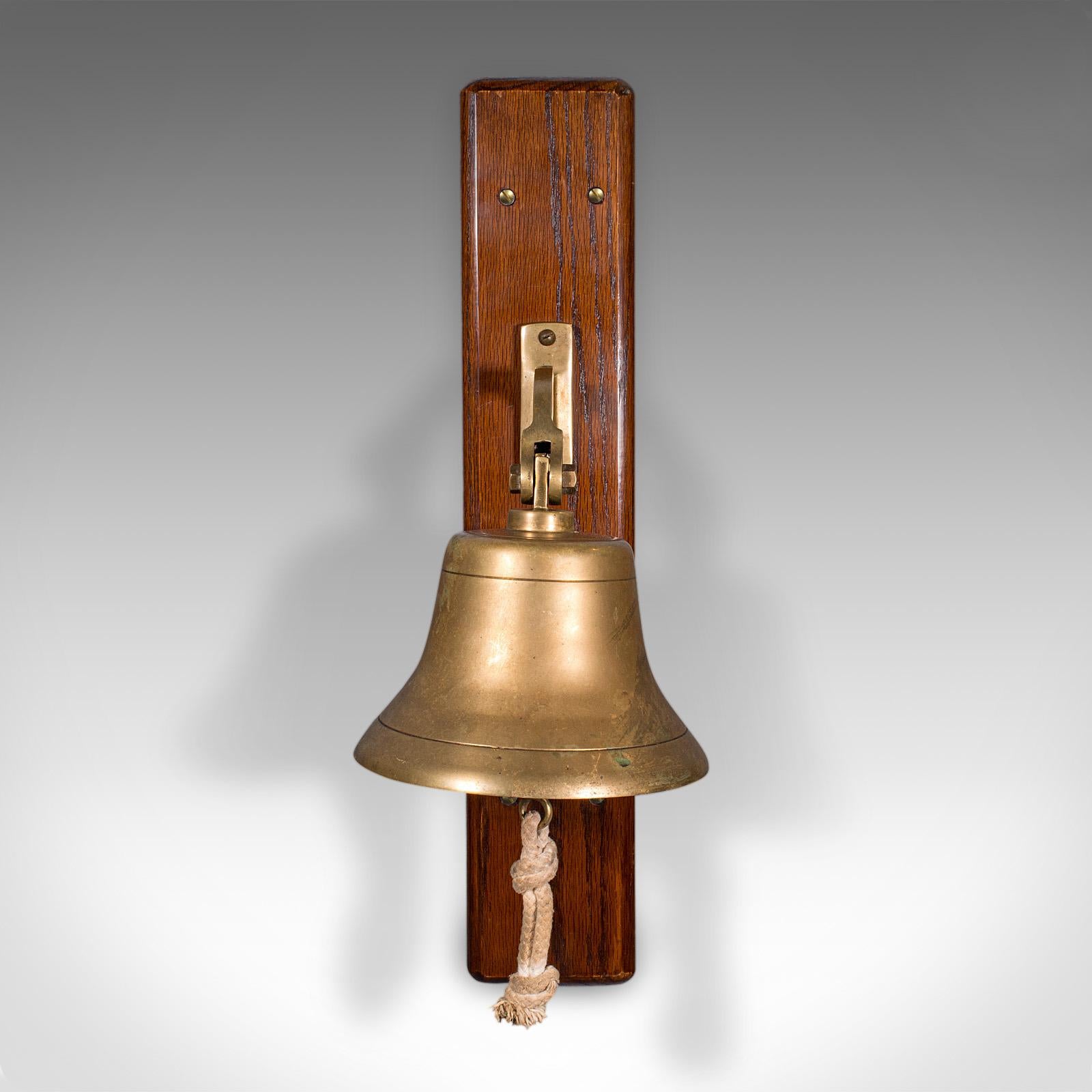 This is an antique school bell. An English, oak and brass wall mounted dinner chime, dating to the Edwardian period, circa 1910.

Raise the alarm or signal for dinner with this confident, charming bell
Displays a desirable aged patina and in good