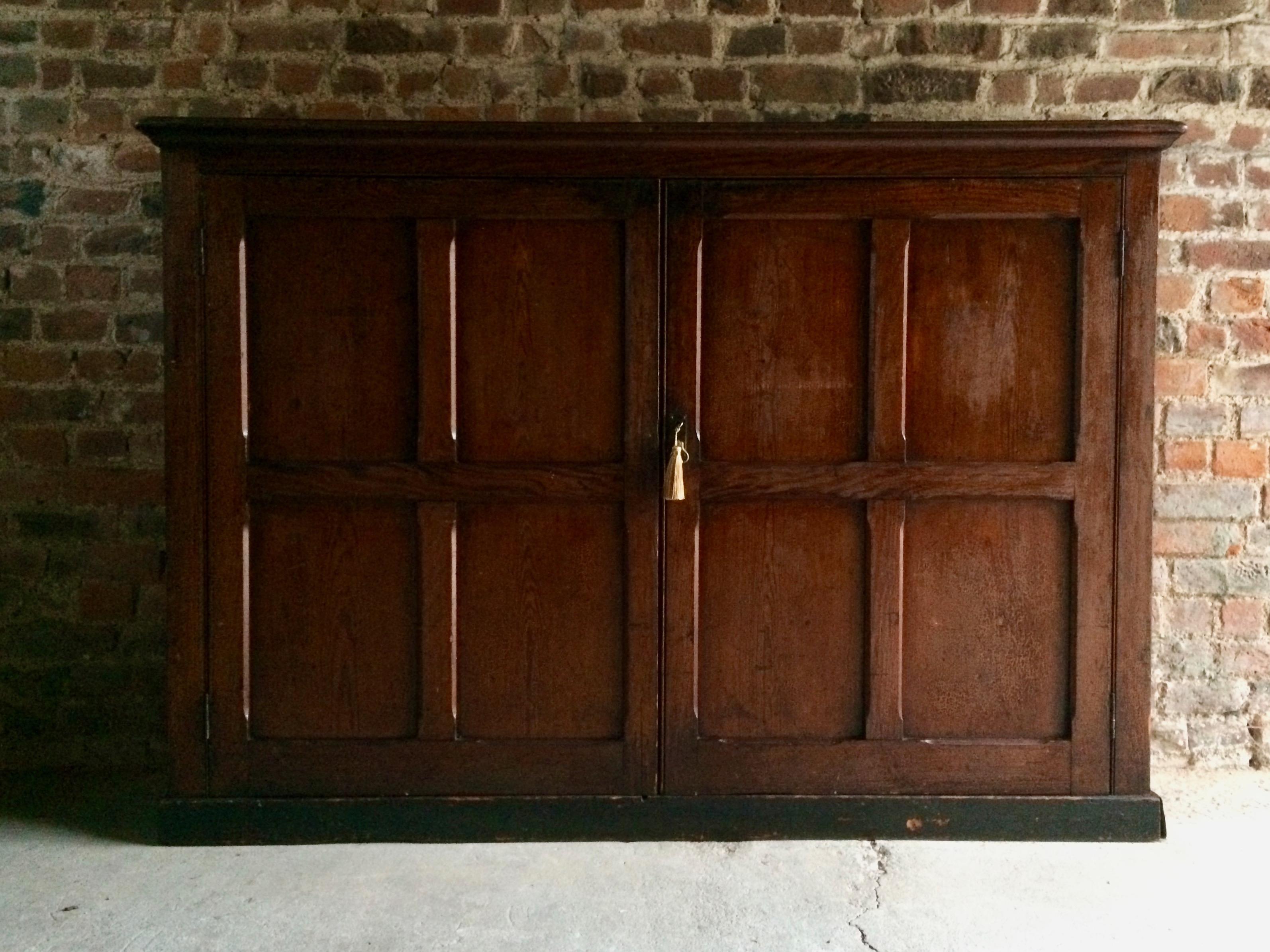 A magnificent 19th century antique English school house cupboard, circa 1875, the rectangular corniced top over two paneled doors with three shelves within, raised on a plinth base, would make an ideal to a boot room or pantry.

Condition: This