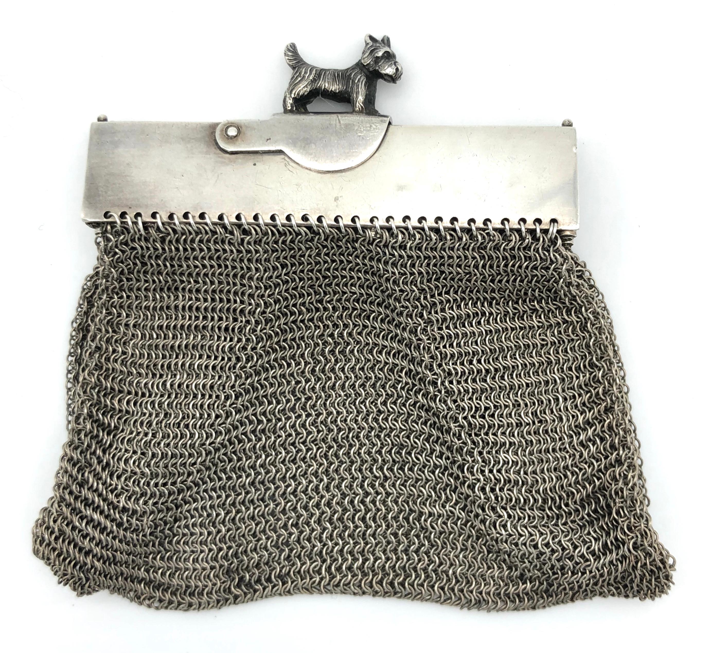 This absolutely adorable highly unusual delicate silver mesh purse has a fully modelled scottish terrier as a fastener. It can be attached to a silverchain or longgard. The purse stays open by means of foldable hinged silver arms. It has an