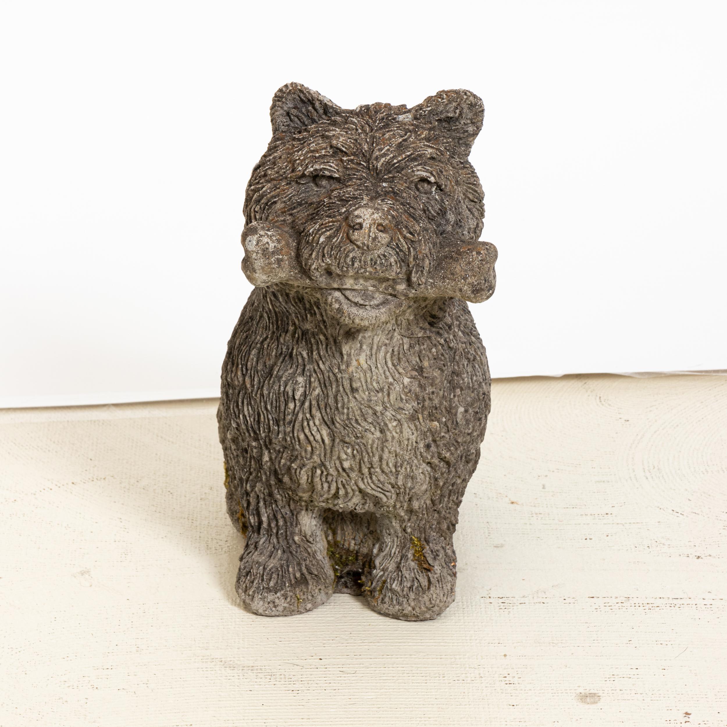 Unique cast stone garden statue in the shape of a Scottie dog holding a bone. Made in England in the early 20th century, this charming statue a playful element to add to the landscape. Good condition, weathered with age and exposure to the elements.