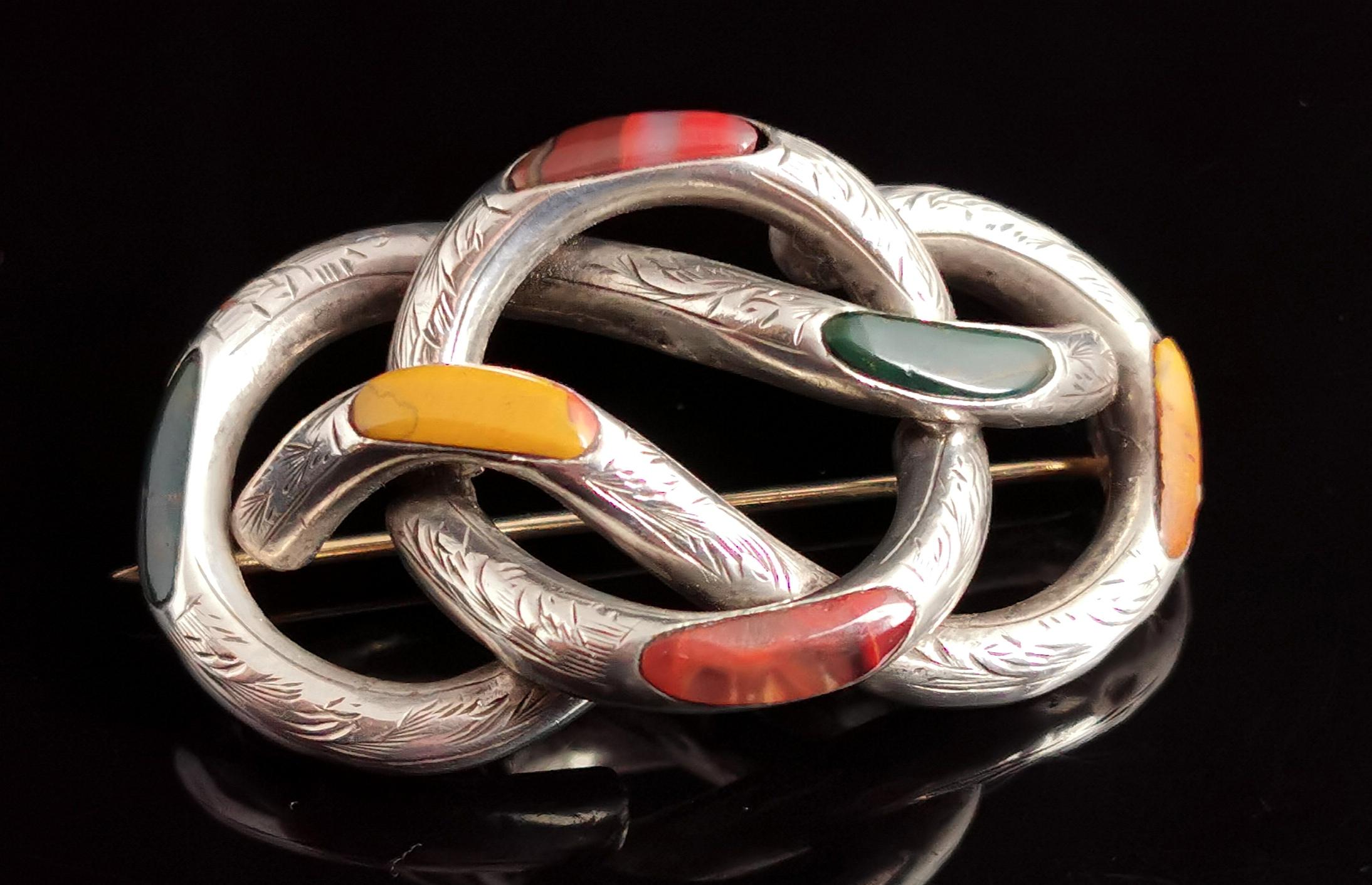 A beautiful antique Scottish agate and sterling silver knot brooch.

An attractive lightly engraved silver knot inset with various agates of different colours.

There is red Jasper with some lovely clear accents, mustard agate and bloodstone, giving