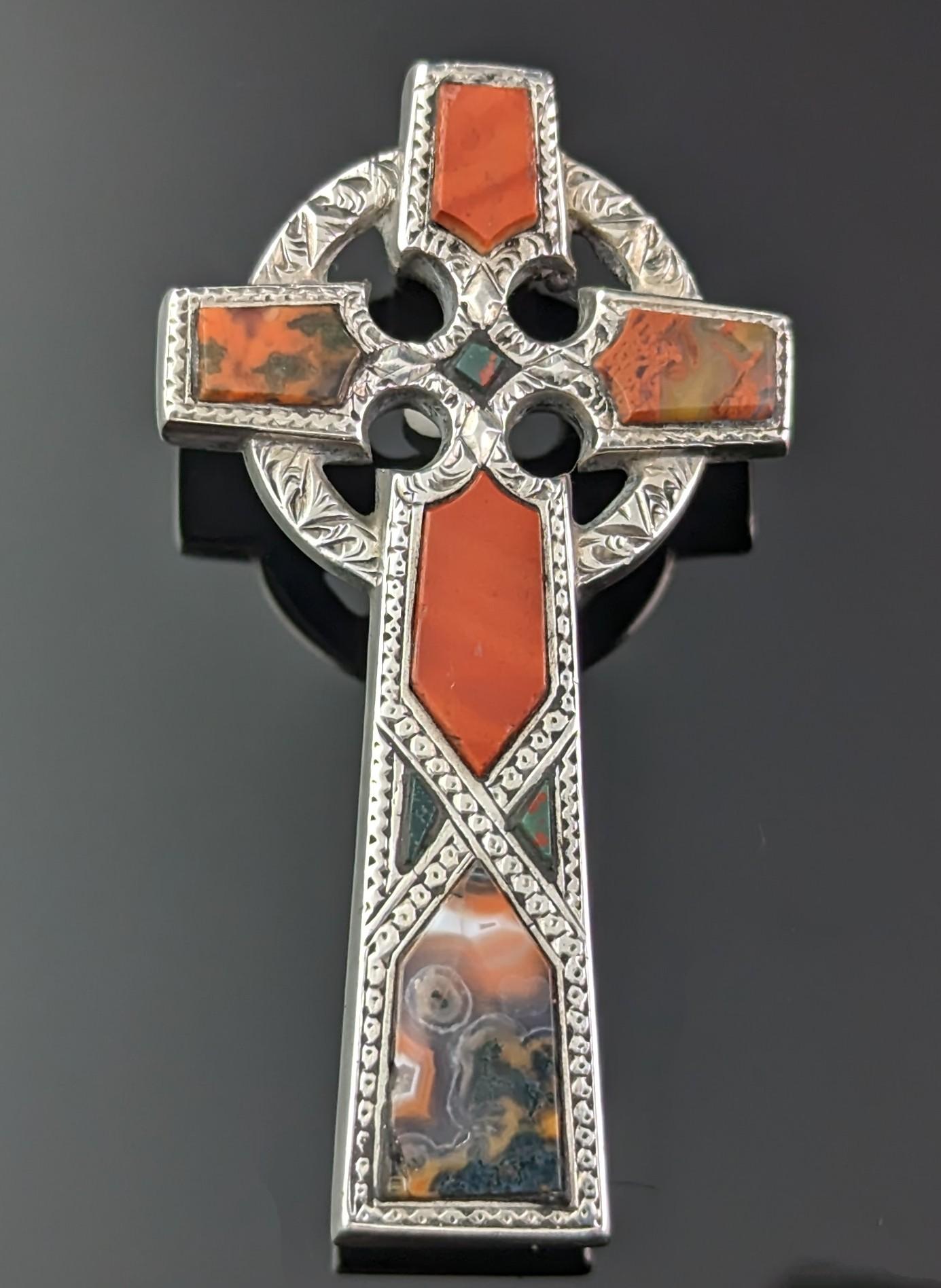 This is just a stunning and grand antique, Scottish agate and Silver brooch designed as a Celtic Cross, an attractive brooch or pin from the Victorian era.

The cool silver cross is chased and engraved to the front with a smooth reverse, the main