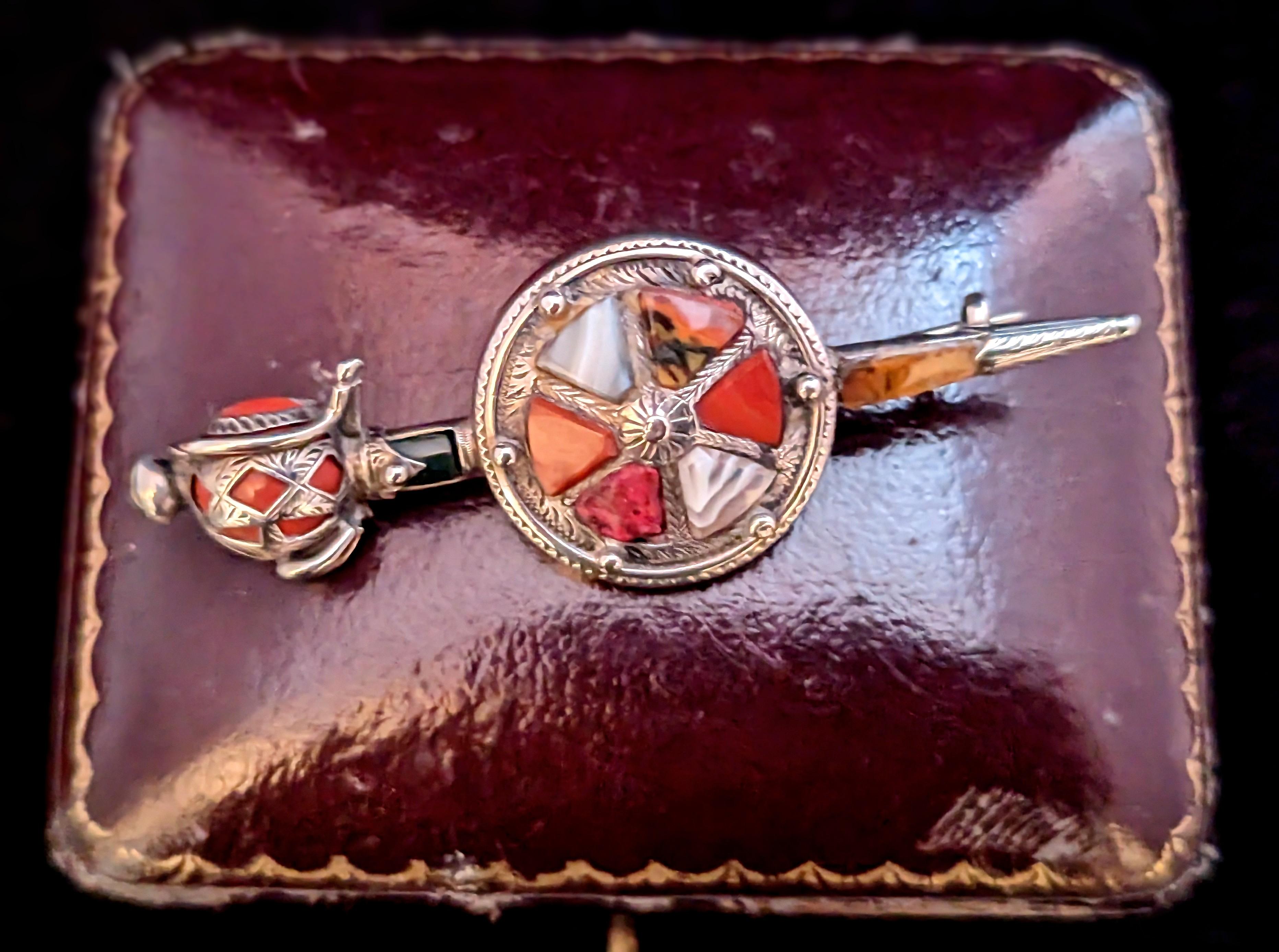 An attractive and unusual antique, Scottish agate and Silver sword and shield brooch.

A very unusual design with the shield,often found with just the sword minus the shield,the sword has a basket hilt set with red Jasper under the sterling silver