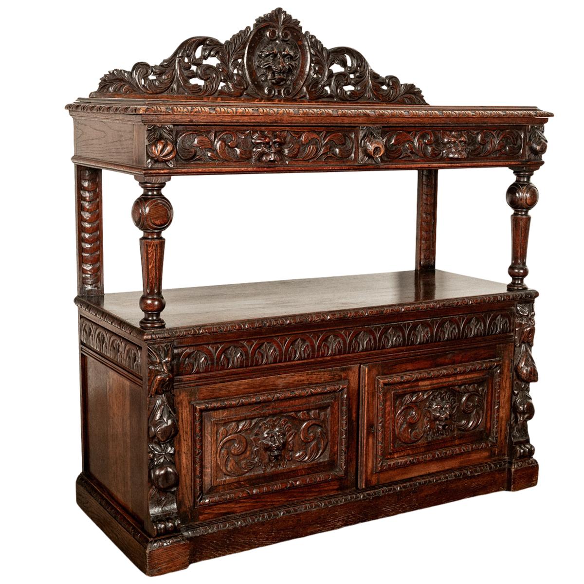 A fine antique Scottish Renaissance Revival carved oak server/ buffet, circa 1860.
This sumptuously carved buffet with a carved back crest (removeable) having a central scrolled cartouche with a lions head & surrounded with carved foliate. The top