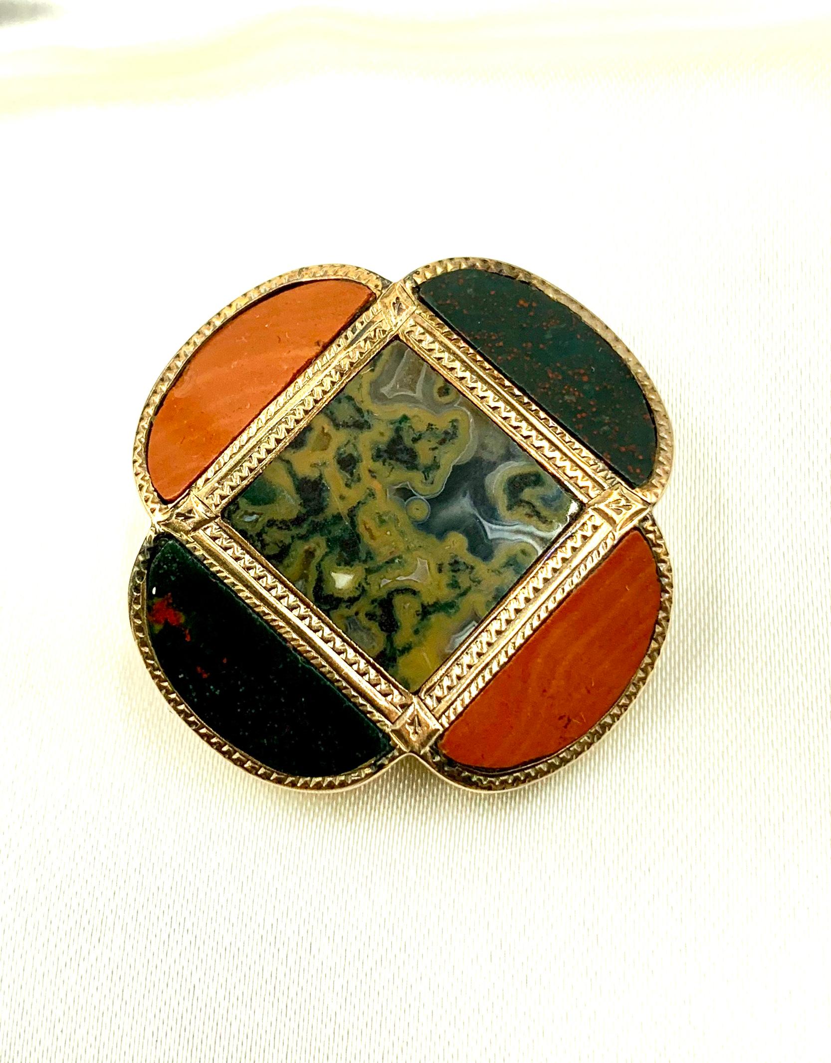 Rare and highly sought after antique Scottish lucky four leaf clover brooch. Composed of a square central figured agate panel inset in a wave motif gold frame, surrounded by four petal elements of alternating bloodstone and jasper inset in gold