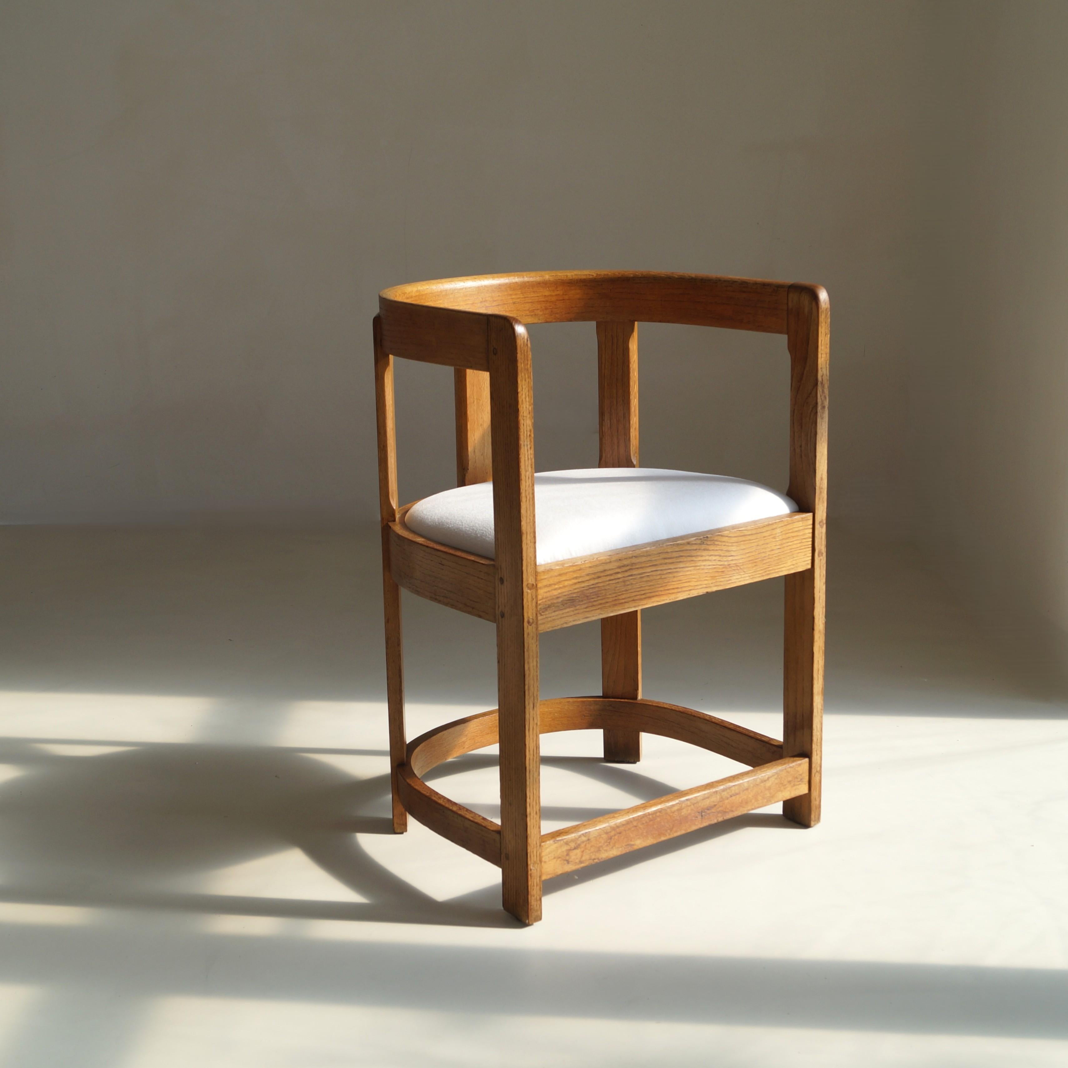 Un sillón antiguo de roble, finamente elaborado, con un característico respaldo en forma de tonel, muy probablemente originario de Escocia hacia la década de 1920. Esta silla ha sido repintada y retapizada recientemente, lo que garantiza que sea a