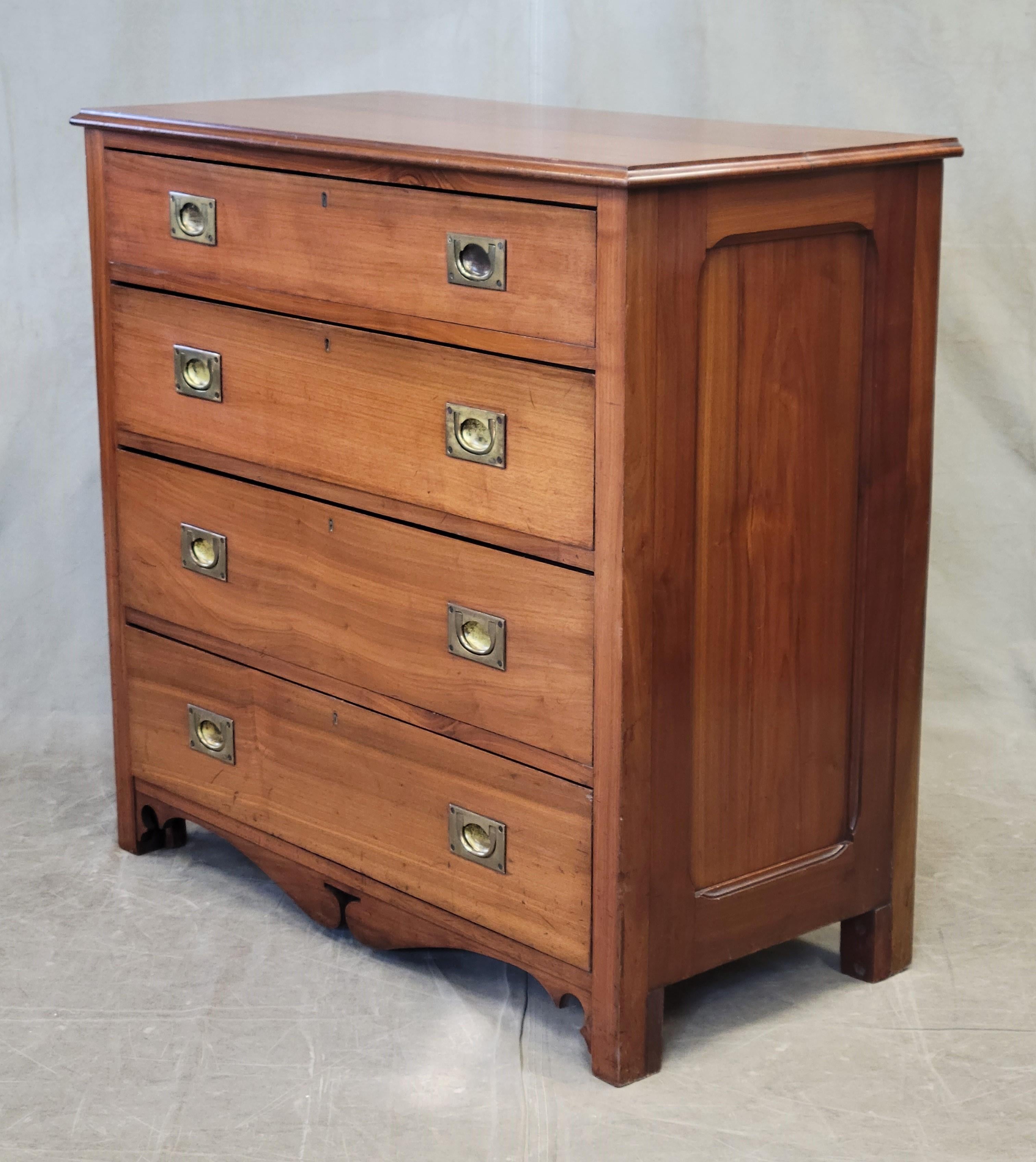 An elegant and functional antique Scottish or English campaign style butler's desk chest of drawer. Crafted out of teak or sycamore (exterior) and elm (interior) with original brass hardware. The top drawer pulls out and folds down to reveal a
