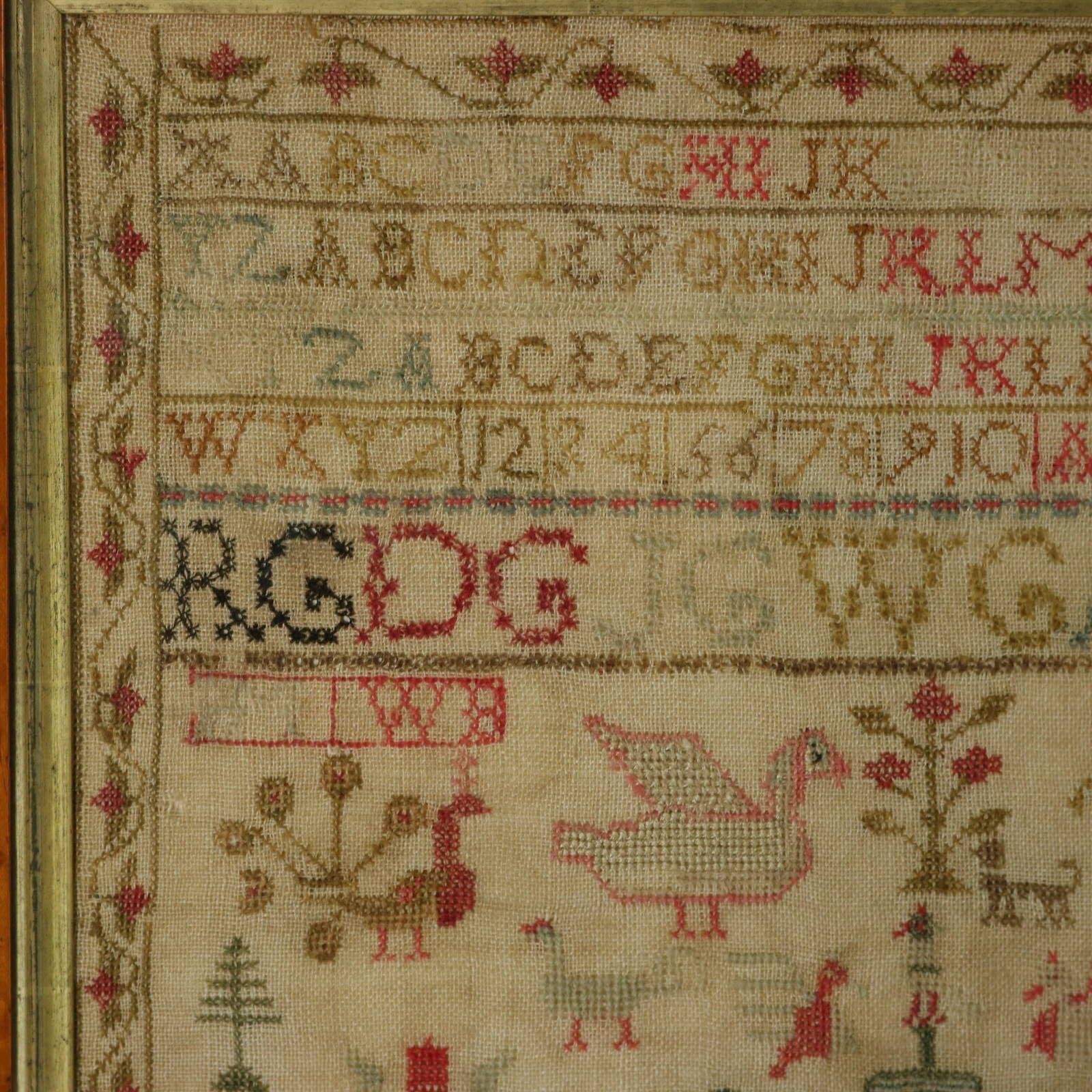 Victorian Scottish Sampler, 1844, by Jean George. The sampler is worked in wool threads on a linen ground, mainly in cross stitch. Meandering strawberry border. Colours red, green, light brown, pink, blue and black. Multiple alphabets A-Z in upper