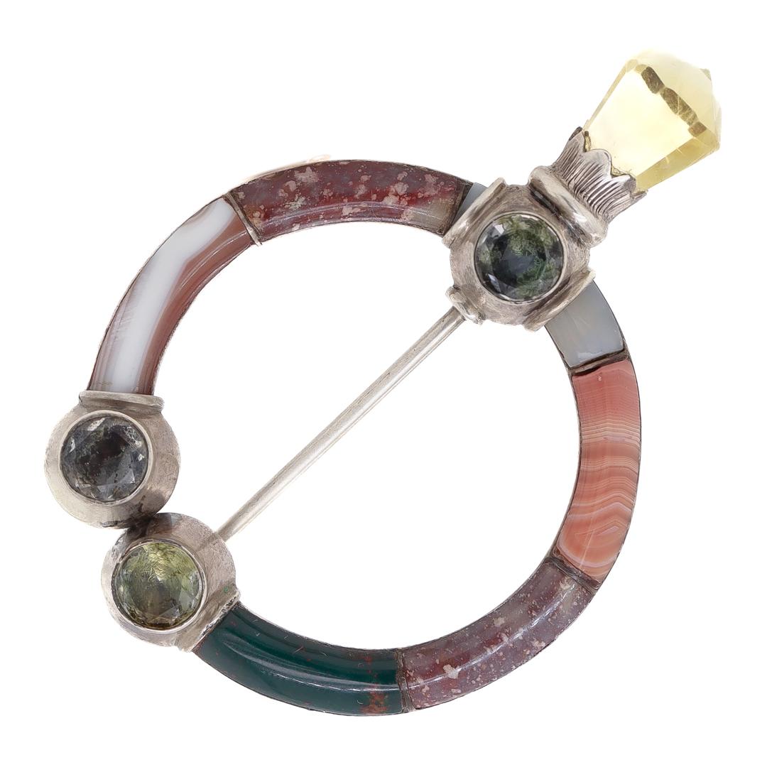 A fine vintage Scottish Brooch or Pin.

A so-called Penannular brooch traditionally used as a closure for cloaks or plaids.

Comprised of a C shaped body divided into 6 different hardstone segments including agate, porphyry, and other
