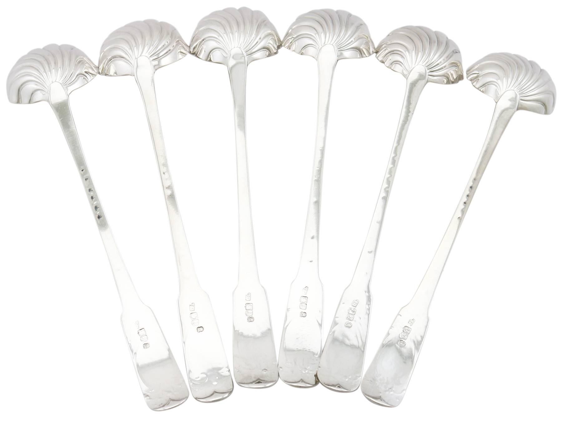 These exceptional George III Scottish sterling silver toddy ladles have been crafted in the Fiddle pattern with a shell shaped bowl.

The anterior surface of each handle is embellished with simplified engraved floral and scrolling leaf