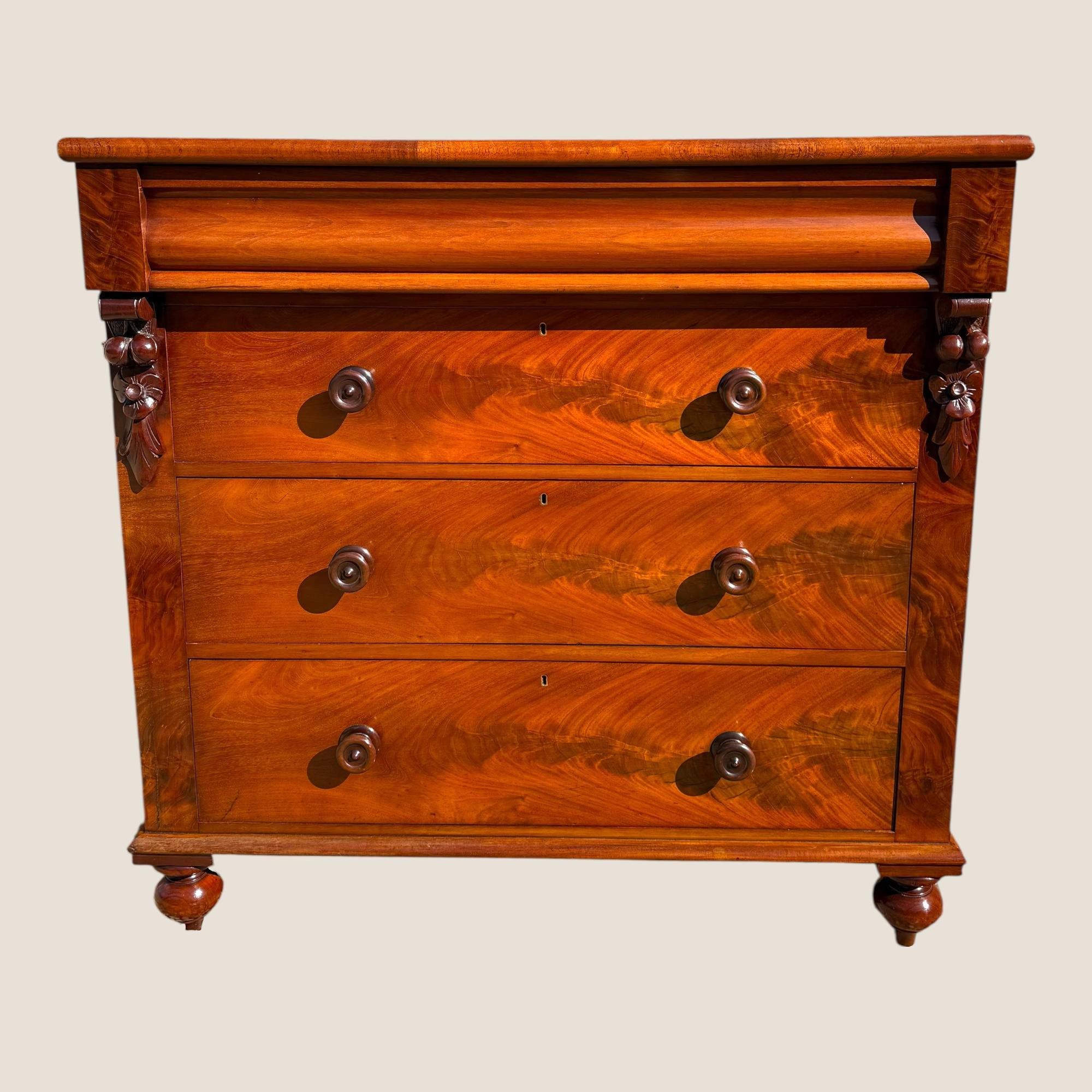 Ecco un'antica cassettiera scozzese vittoriana (1837-1901) in mogano fiammato con maniglie in legno. Questa bellissima cassapanca impiallacciata in mogano a fiamma presenta elementi floreali intagliati sul davanti, un cassetto discreto all'interno