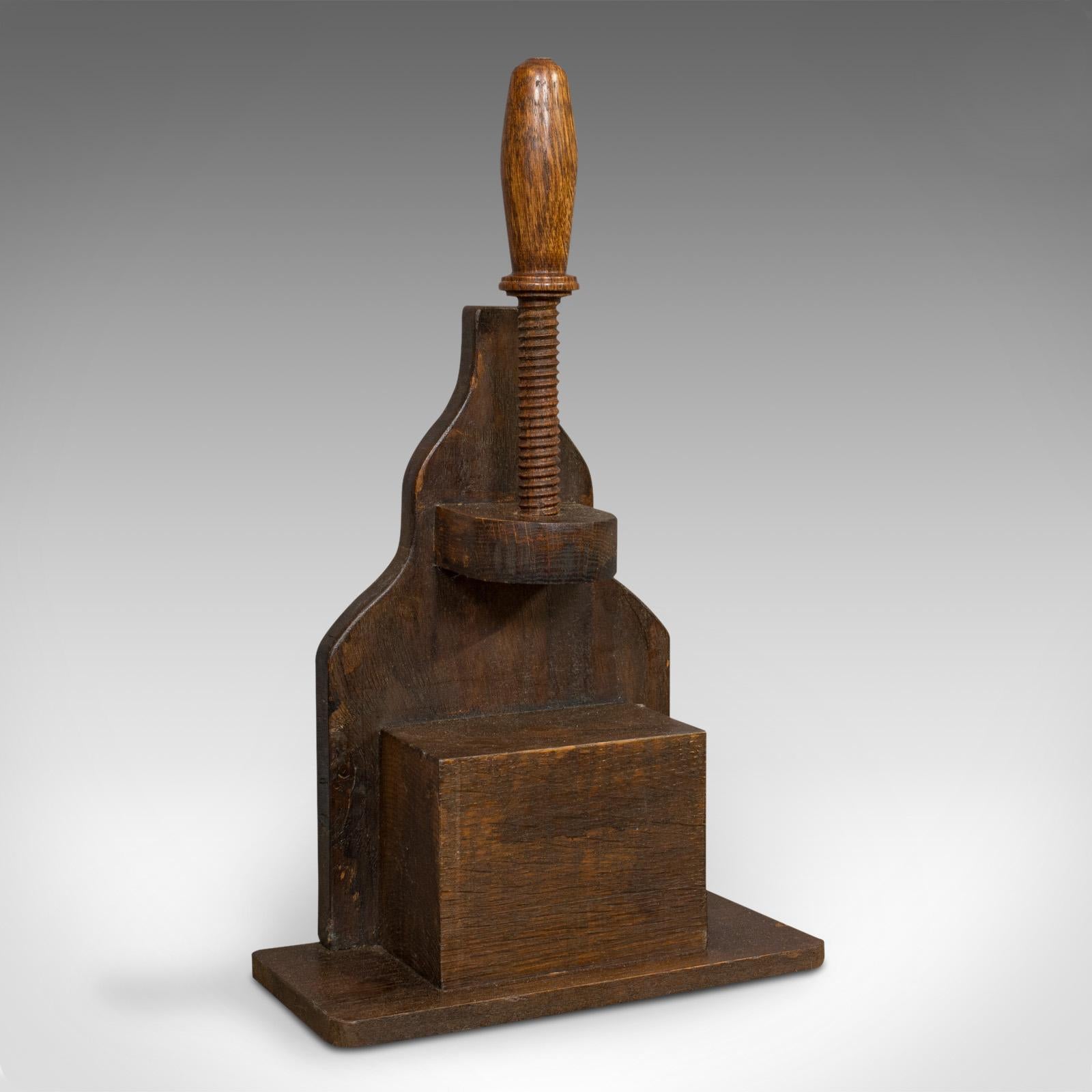 This is an antique screw press. An English, oak nutcracker, bookbinding or kitchen press, dating to the Victorian period, circa 1880.

Fine Victorian press
Displays a desirable aged patina
Oak shows fine grain interest
Turned oak screw offers
