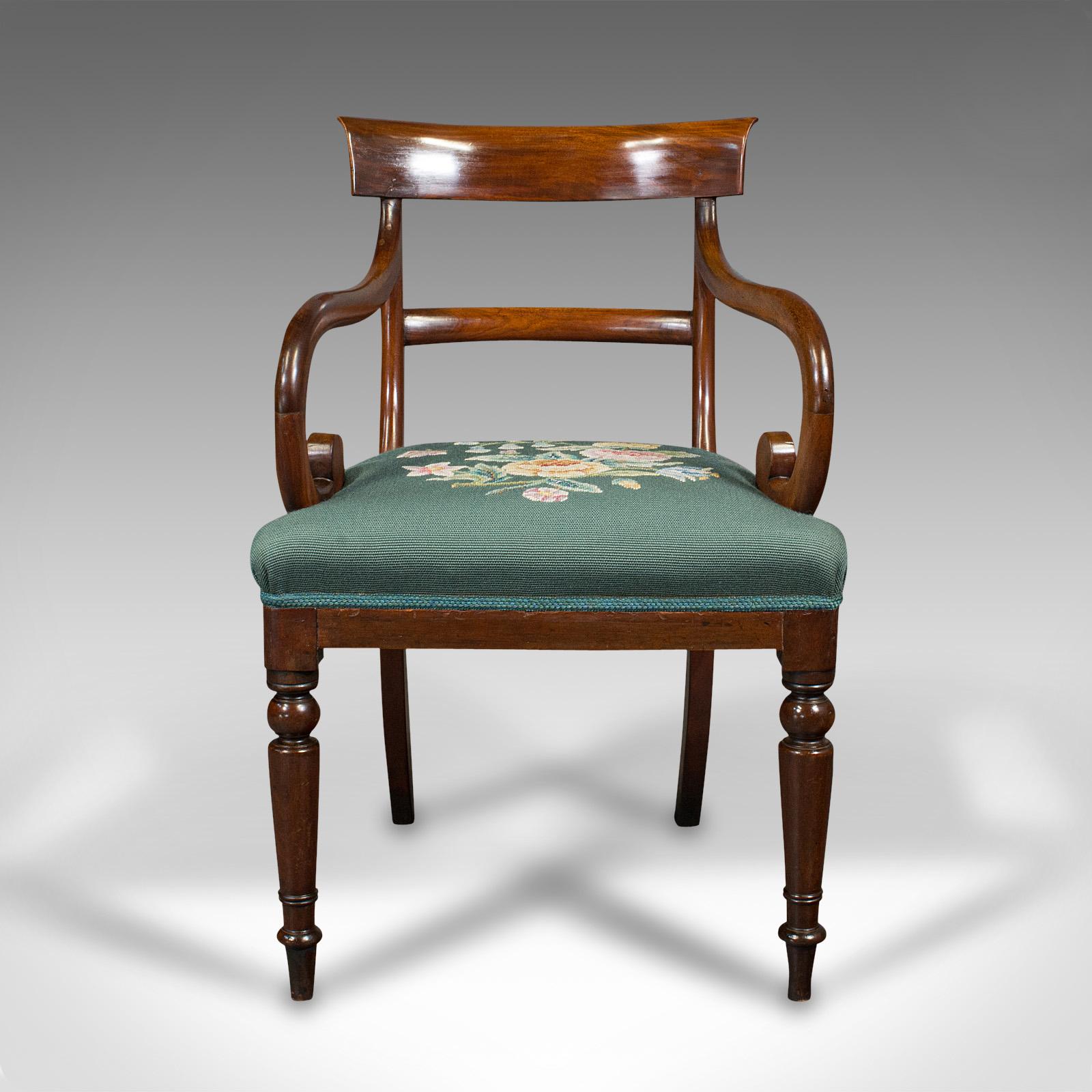 This is an antique scroll arm desk chair. An English, mahogany armchair with needlepoint upholstery, dating to the Regency period, circa 1820.

Sinuous, scrolled forms and appealing colour
Displays a desirable aged patina throughout
Select