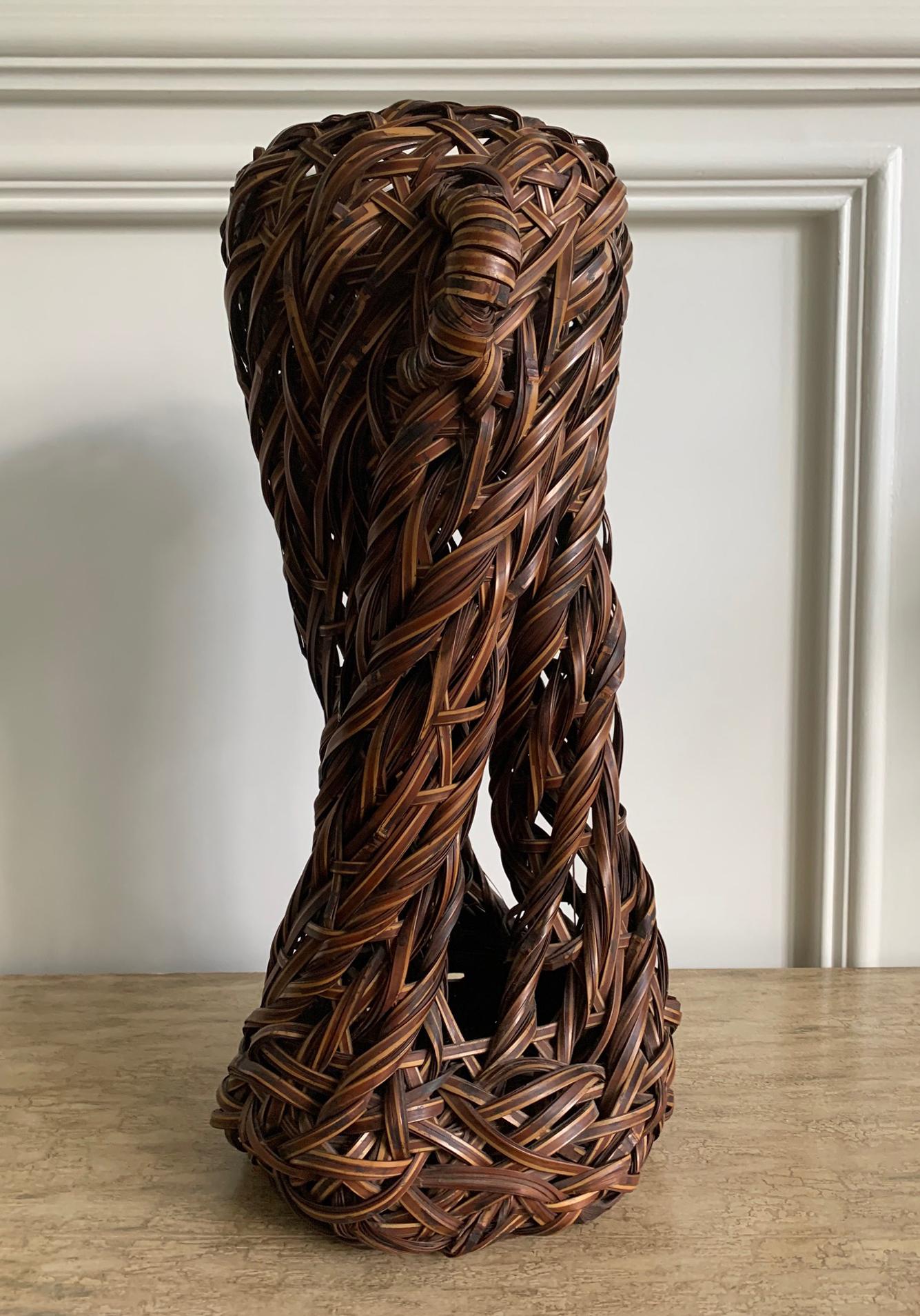 A visually arresting Japanese bamboo Ikebana basket that is more a sculpture than a vase. The open design was largely achieved through an expert hand and almost exclusively the bundled weaving technique. The flattened bamboo strips were manipulated