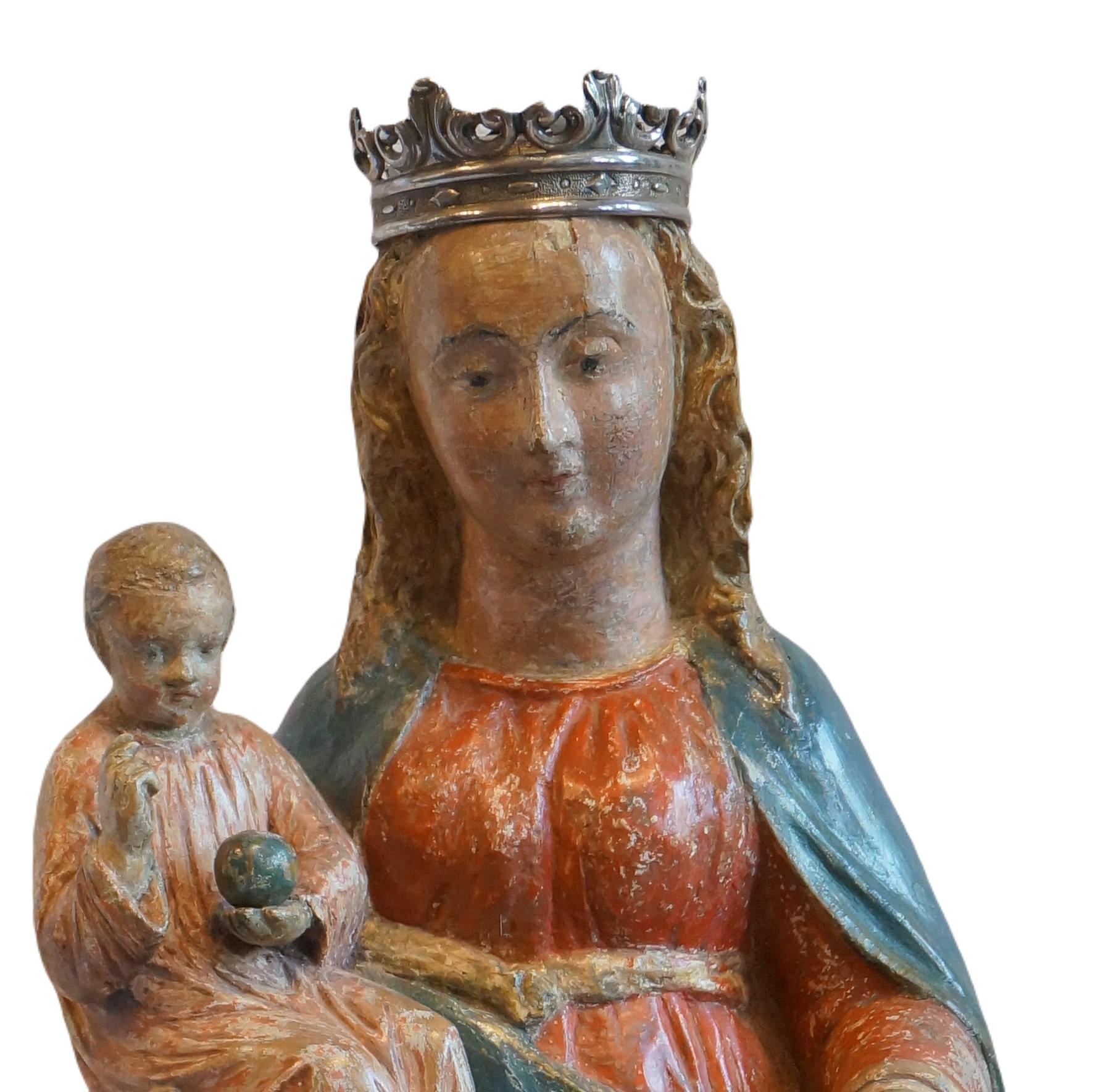 Sculpture of Mother Mary with the Child Jesus.
Mary has the child on her right hand. Jesus makes a blessing gesture and wears a small globe. ( a sign off His power over the world)
Mother Mary has a grape in her left hand.
The faces of both Mother