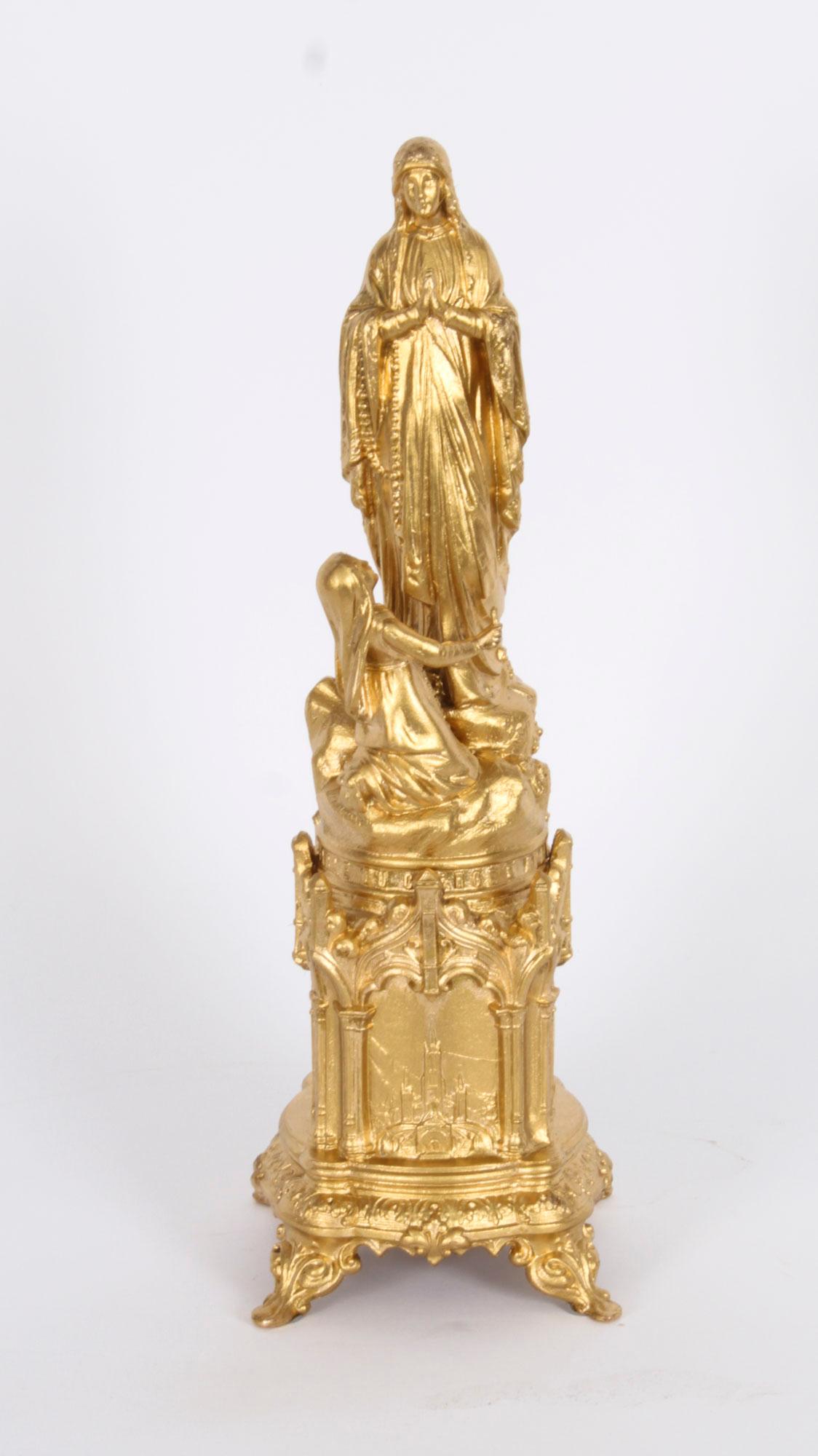 An antique French ormolu souvenir of Lourdes, showing St Bernadette before the Virgin Mary as the 