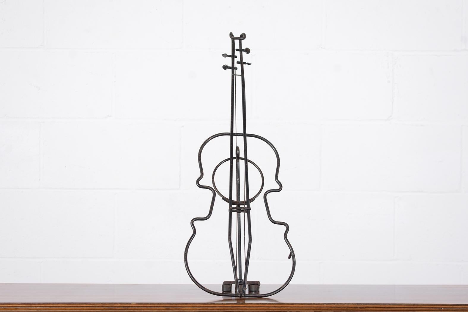 Cette extraordinaire sculpture française antique de violon est en bon état et est magnifiquement fabriquée à la main en fer forgé. Cette pièce est accrocheuse et présente des détails incroyablement forgés et travaillés sur un piédestal ; le violon