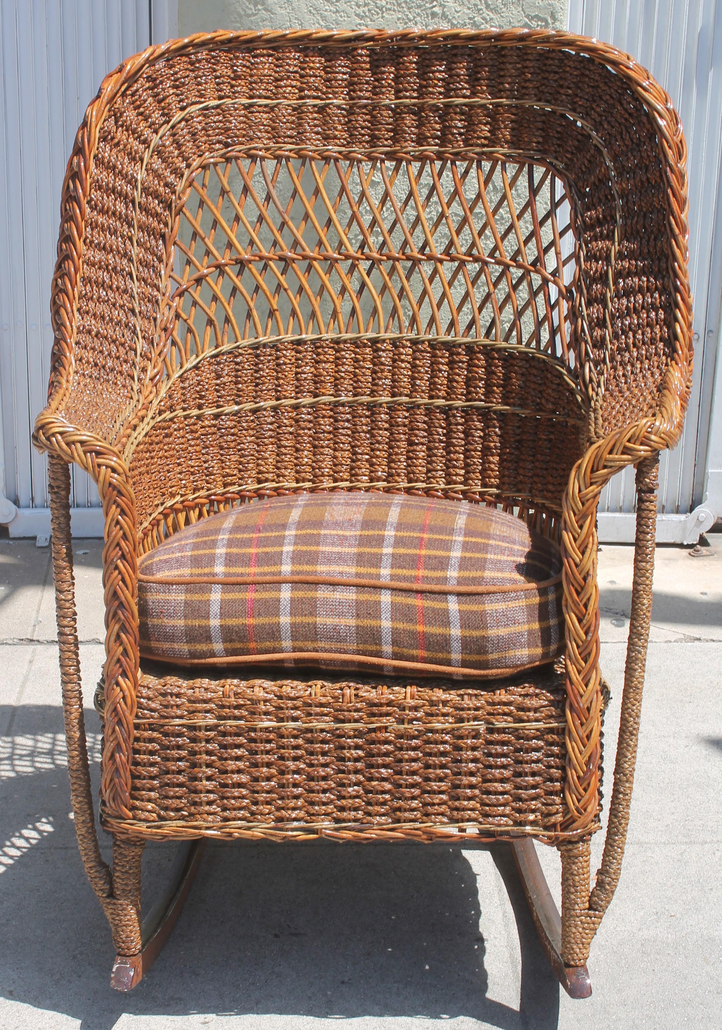 This amazing large wicker and sea grass rocking chair is from the early 20th century and in fantastic condition. It comes with a cushion as well made from a vintage blanket.