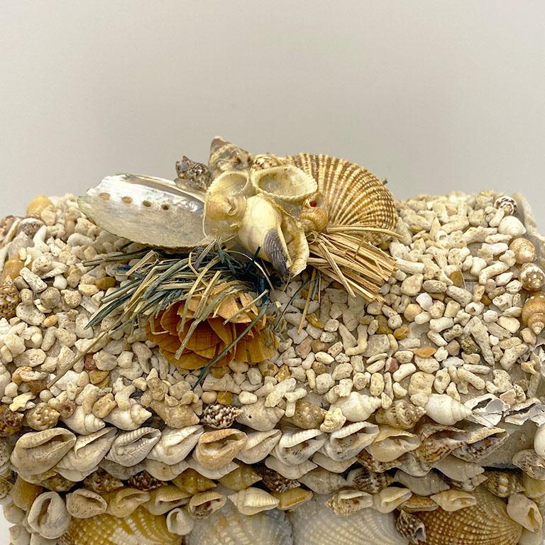 A beautiful coffin shape trinket box encrusted with shells. This box would be stunning on a dressing table, side table, or coffee table. Its hinged lid opens to fit miscellaneous items. A bouquet of dried flowers tops the lid. 

Measures: 5