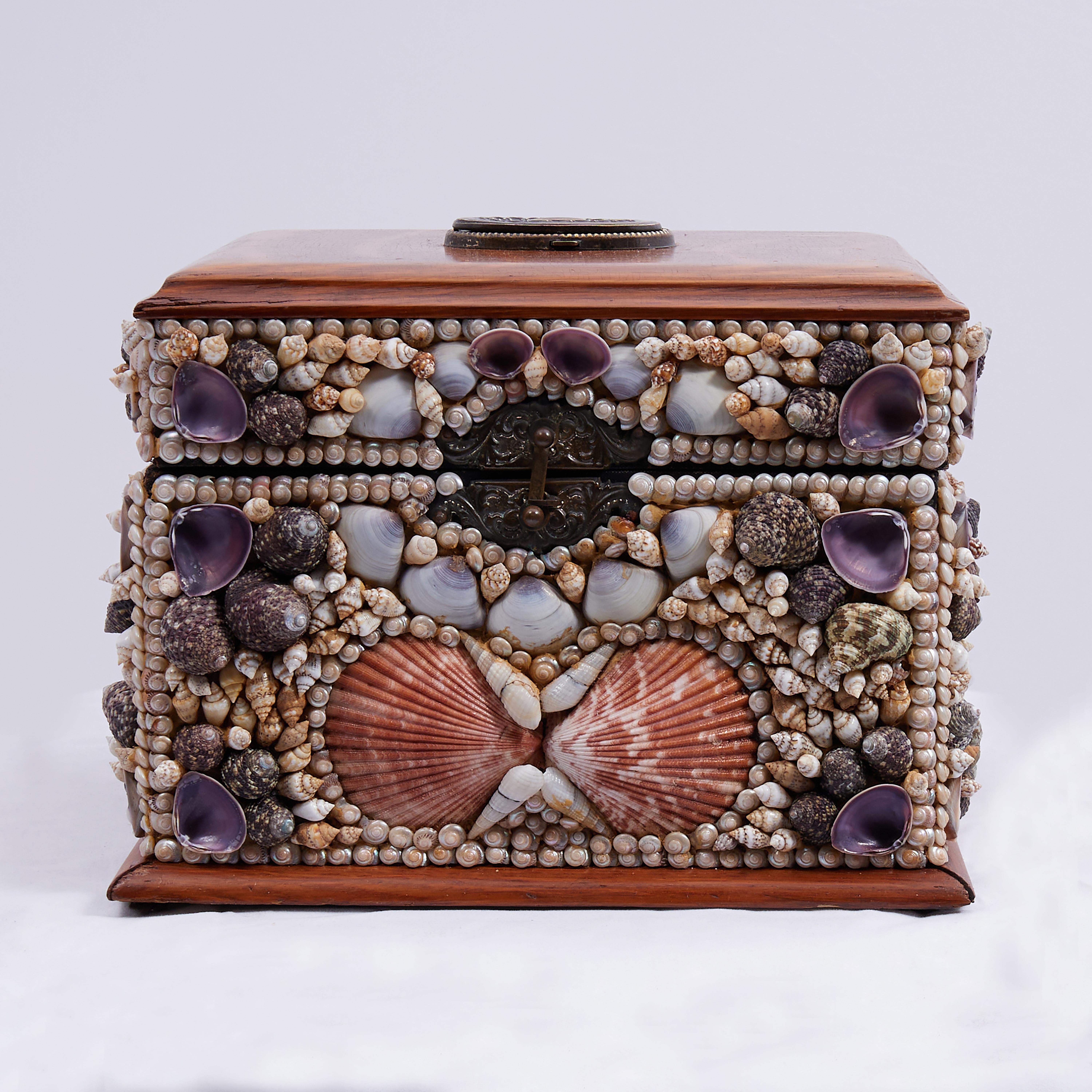 Impresionante caja antigua con tapa, fabricada en roble, con relicario incorporado en la parte superior, interior forrado de fieltro y ambiciosamente decorada con conchas marinas exóticas dispuestas con esmero en orden decorativo. 