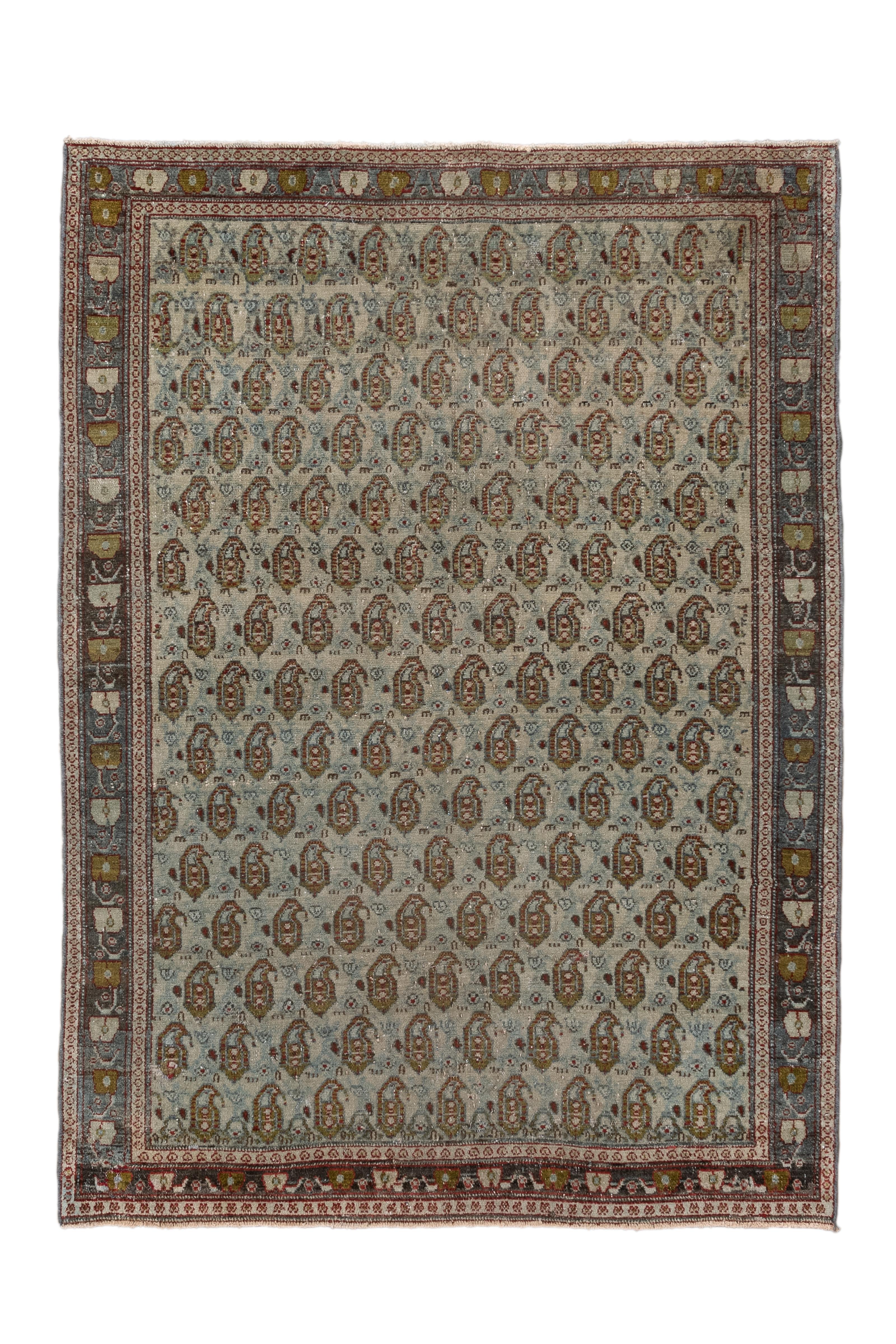 Questo squisito tappeto Senneh antico presenta un raffinatissimo motivo boteh (paisley) a tutto campo nei toni del celeste, del ruggine e dell'avorio, incastonato in un'equilibrata bordura di rosette stilizzate e di viti. Tessuto nella città curda