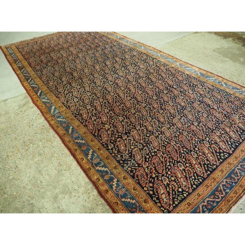 Antique kelleh carpet or long rug from the region of Serabend with all over boteh design on a dark indigo blue ground, the boteh are drawn in a manner that gives them a great sense of flowing movement. The use of pastel shades in the boteh and