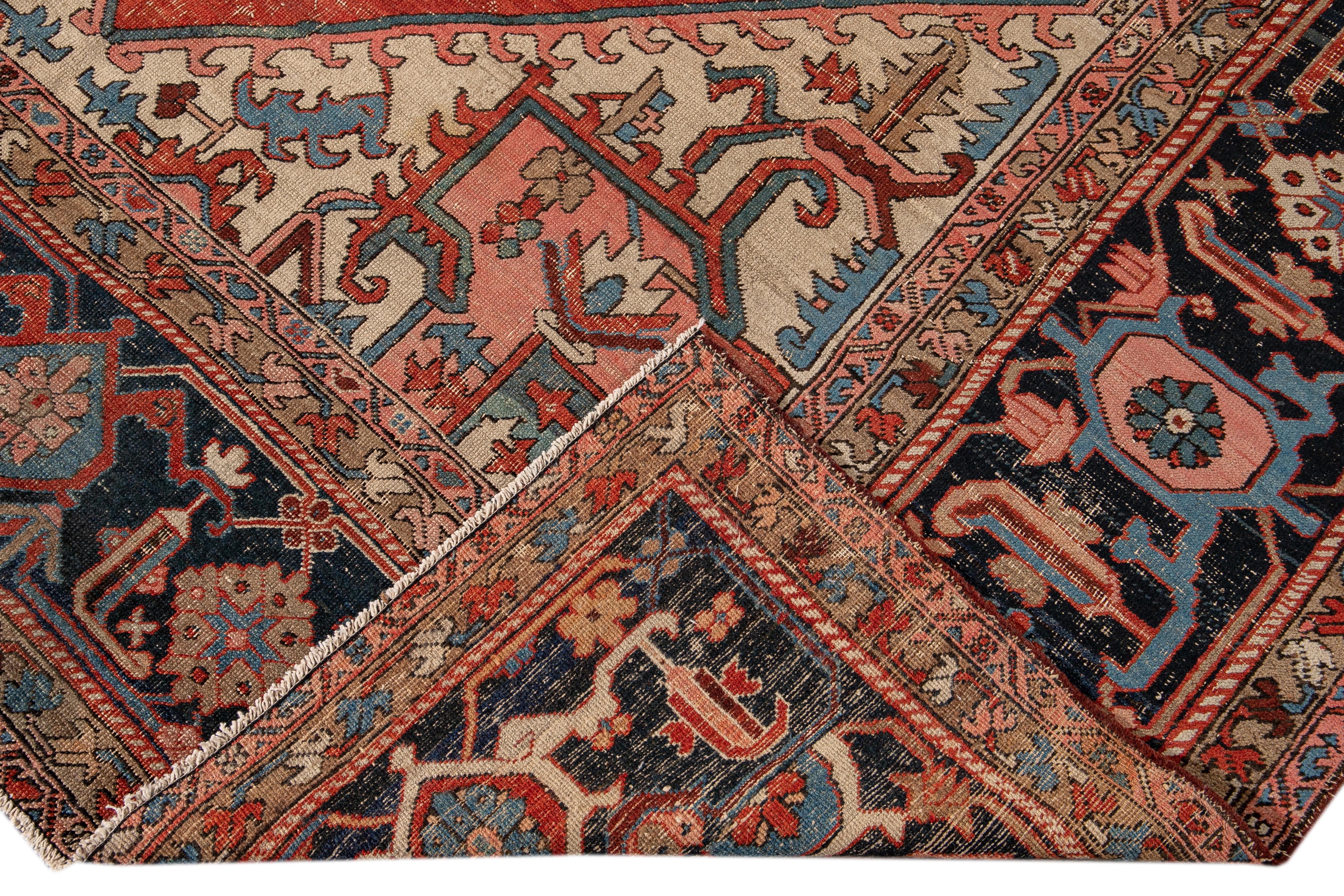 Beautiful antique Persian Serapi hand-knotted wool rug with a red and ivory field. This Heriz rug has a blue frame and peach and brown accents in an all-over gorgeous geometric medallion floral distressed design.

This rug measures: 9'5
