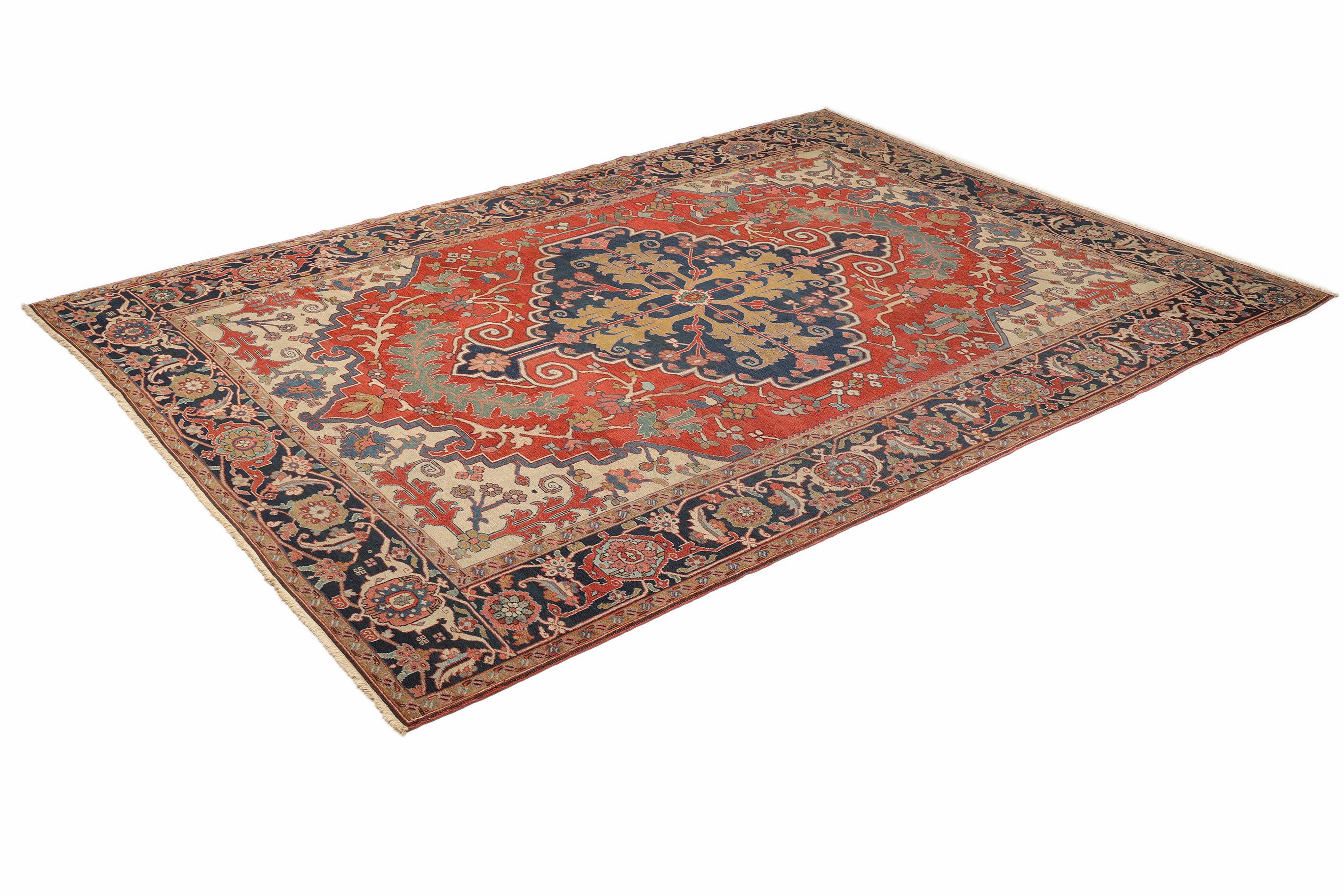 Authentique tapis persan Serapi, noué à la main en Iran, vers 1900.

Il se caractérise par un médaillon central audacieux aux motifs géométriques, encadré par une bordure florale complexe.

Champ rouge riche aux reflets bleu foncé, ivoire et or,