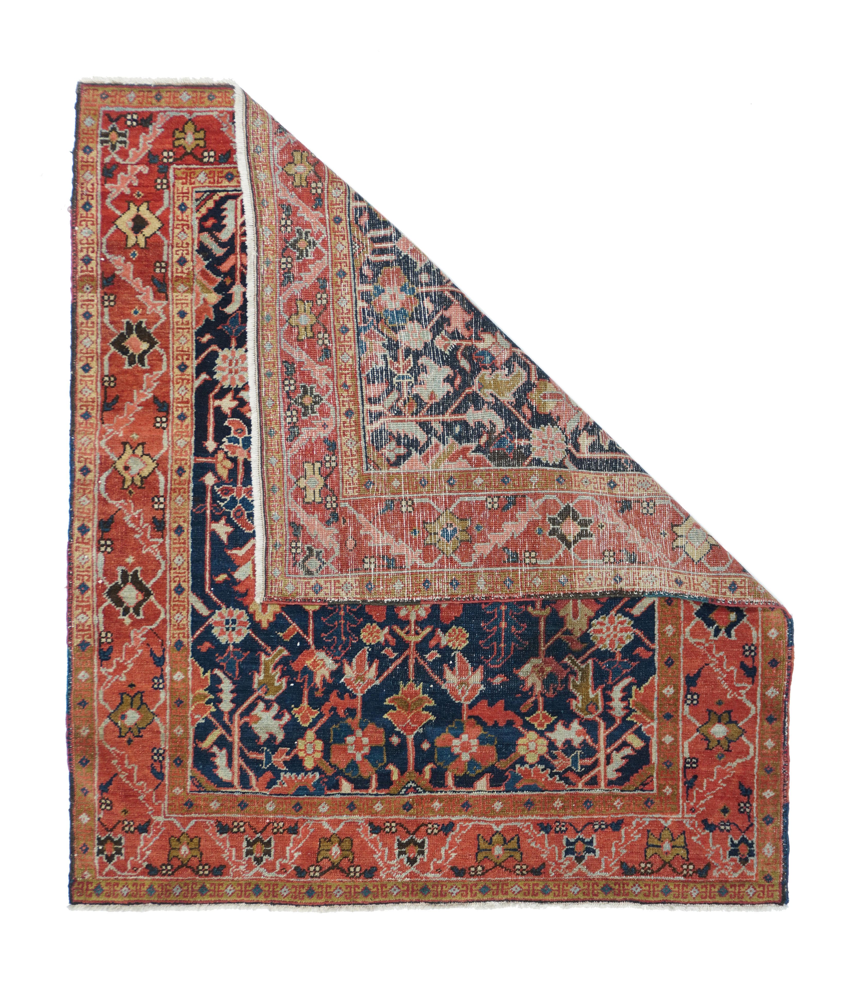 Antique Serapi Rug 4'3'' x 5'. The dark blue field shows palmettes and deeply barbed leaves, all on stiff stems, with a layered hexagonal centre. Red border with strip style pattern of serrated slanted leaves and simple palmettes. Moderate weave.