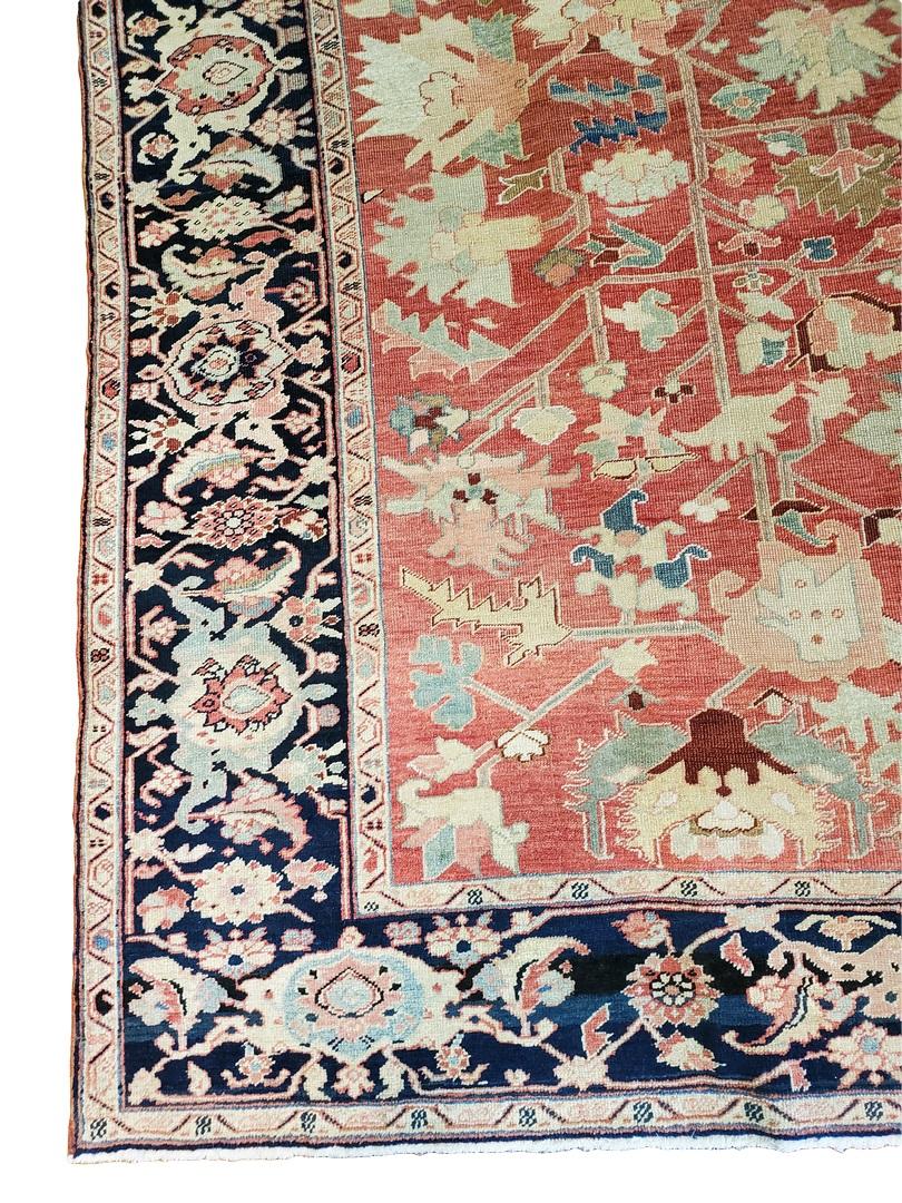 This gorgeous rug was handmade in Serapi in circa 1900. The rug has a beautiful design using faded Red, Blues, and Ivorys in an all-over floral design. The light delicate colors on the foreground of the rug are complimented by its strong Navy