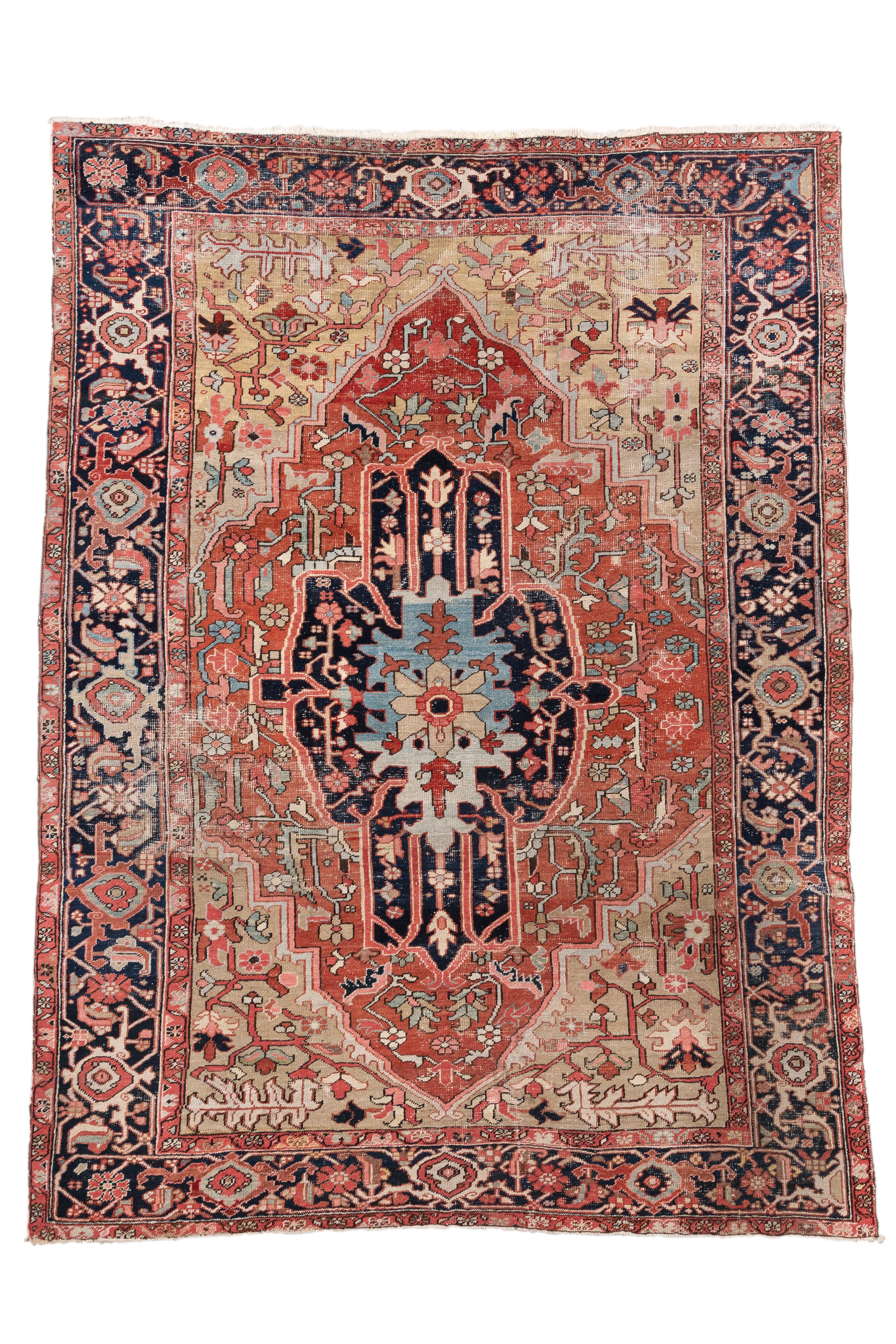  This antique Serapi rug, handwoven circa 1880, showcases the classic aesthetic of Northwest Persian tribal weavings—bold, geometric, and deeply rooted in tradition. The composition is anchored by an elongated central medallion rendered in midnight