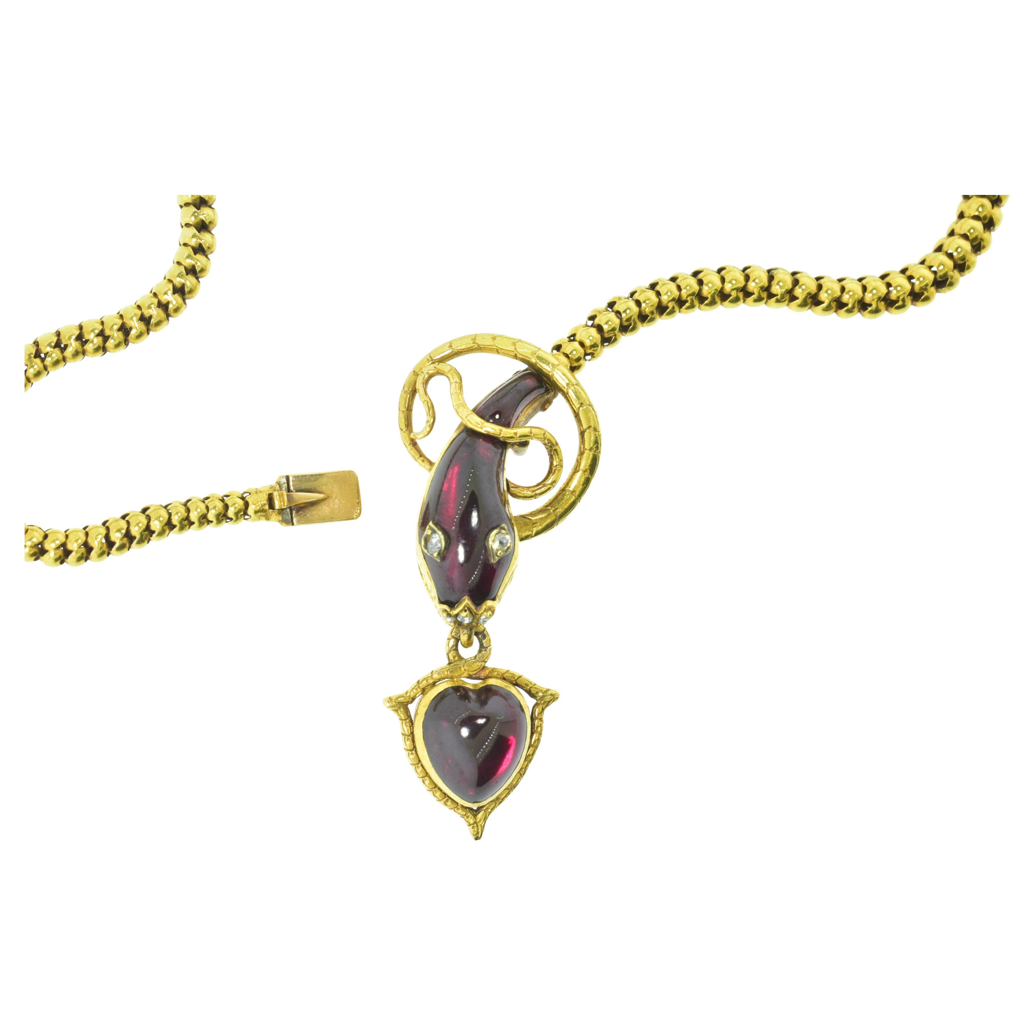 Antique Necklace hand made in 18K yellow gold with a serpent and heart motif, the heart and serpent have fancy cut red garnets and the serpent's eyes and nose are rose cut diamonds.  

This necklace is in fine condition, 16.25 inches long with the