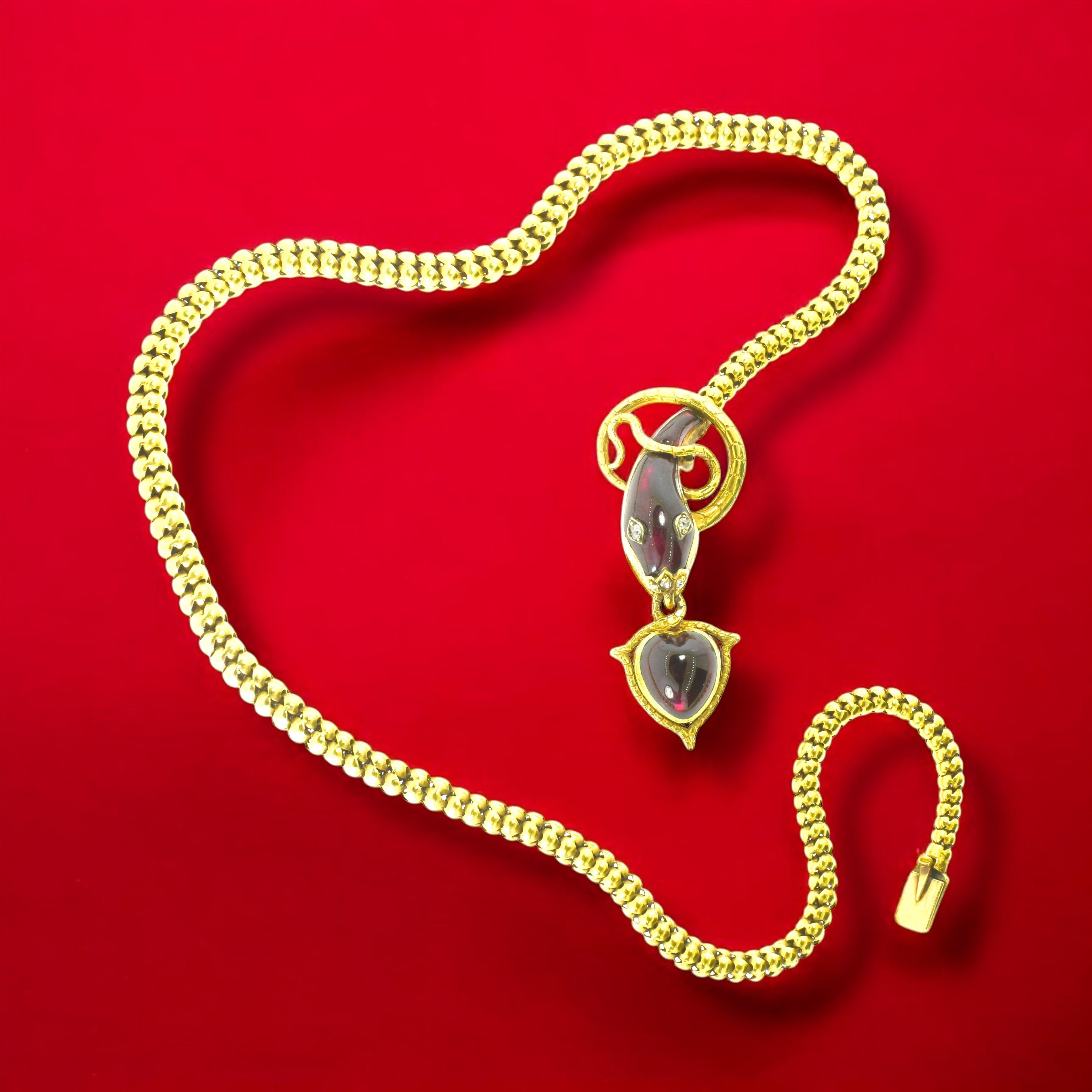 Collier ancien fait à la main en or jaune 18K avec un motif de serpent et de cœur, le cœur et le serpent ont des grenats rouges de taille fantaisie et les yeux et le nez du serpent sont des diamants de taille rose.

Ce collier est en bon état, 16,25