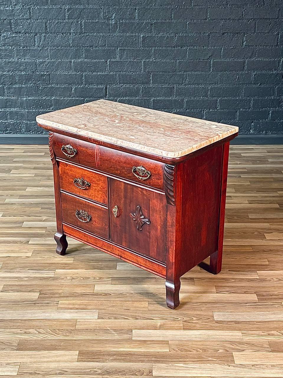 Condition: Original Vintage Condition

Materials: Antique Red-Stained Maple, Original Pink Marble, Ornate Brass Pulls
Style: American Antique

This exquisite American antique entry stand dresser exudes old-world elegance with its rich red-stained